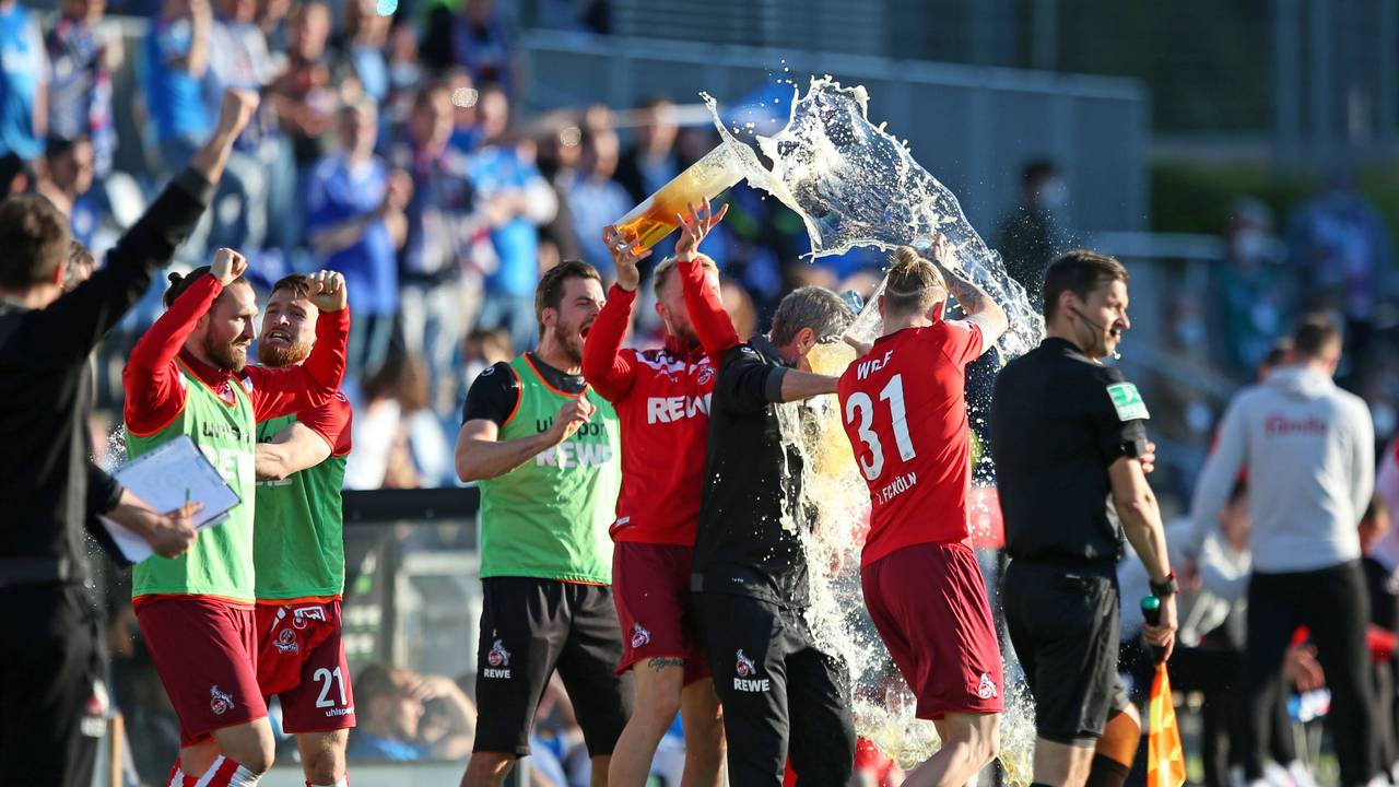 Friedhelm Funkel wird mit Bier übergossen beim Klassenerhalt mit dem 1. FC Köln 2021.