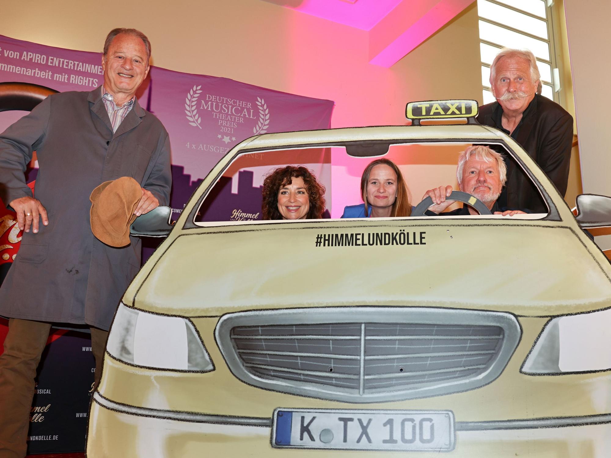 Tom Gerhardt, Isabel Varell, Vera Bolten, Jürgen Becker und Henning Krautmacher an einer Taxi-Attrappe.