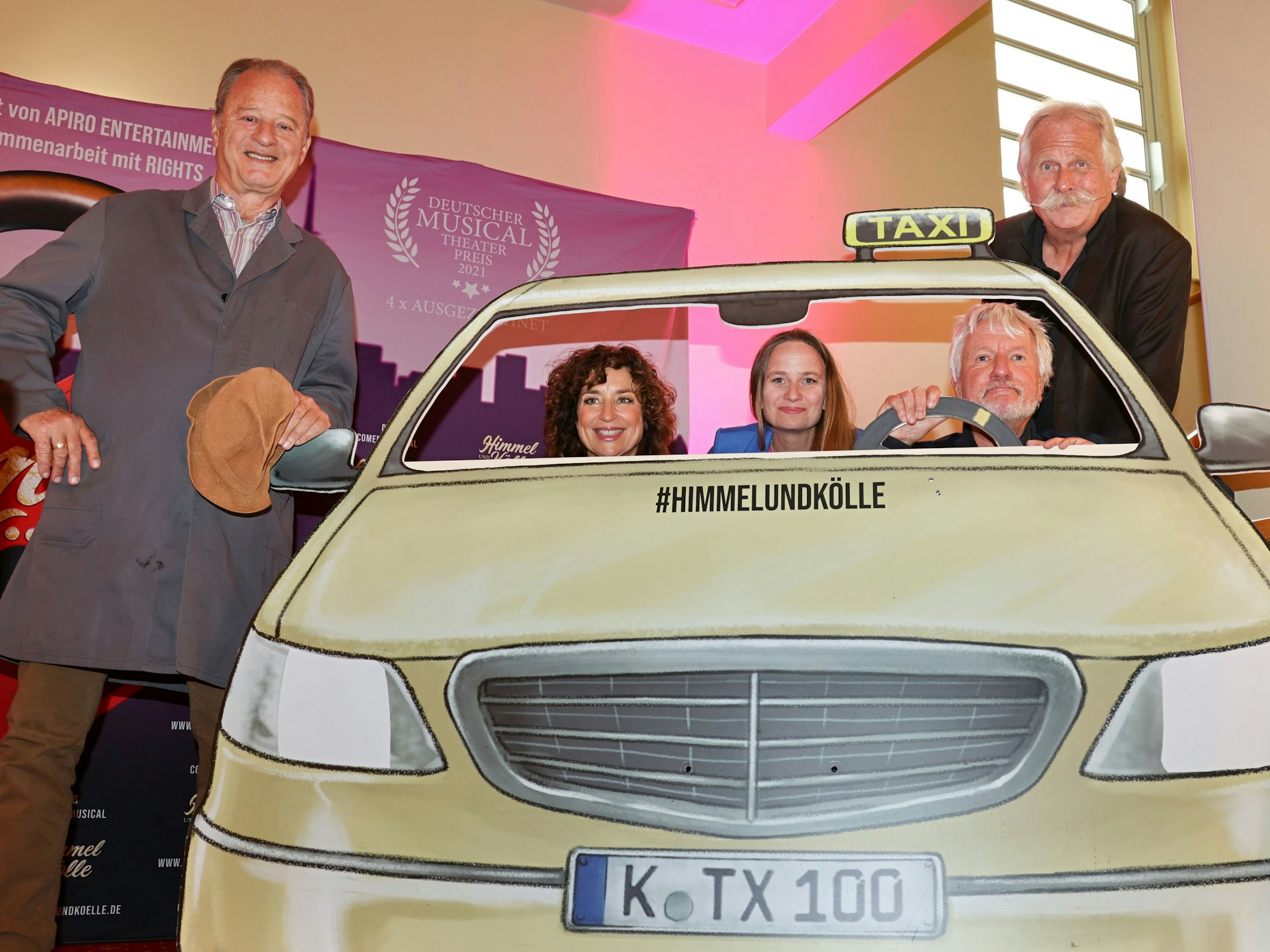 Tom Gerhardt, Isabel Varell, Vera Bolten, Jürgen Becker und Henning Krautmacher an einer Taxi-Attrappe.