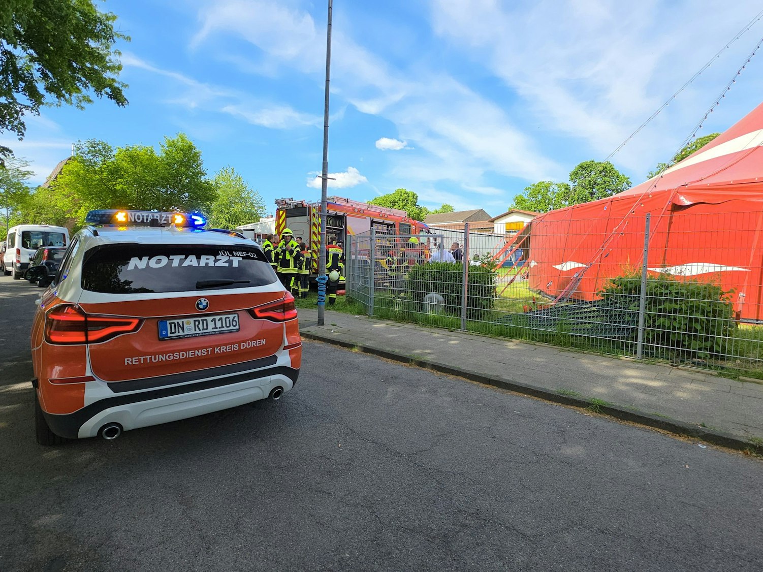 Ein Notarztfahrzeug steht am 8. Mai 2025 vor einem Zirkuszelt. Beim Brand eines Zirkuszeltes im Kreis Düren sind 17 Kinder und drei Erwachsene verletzt worden.