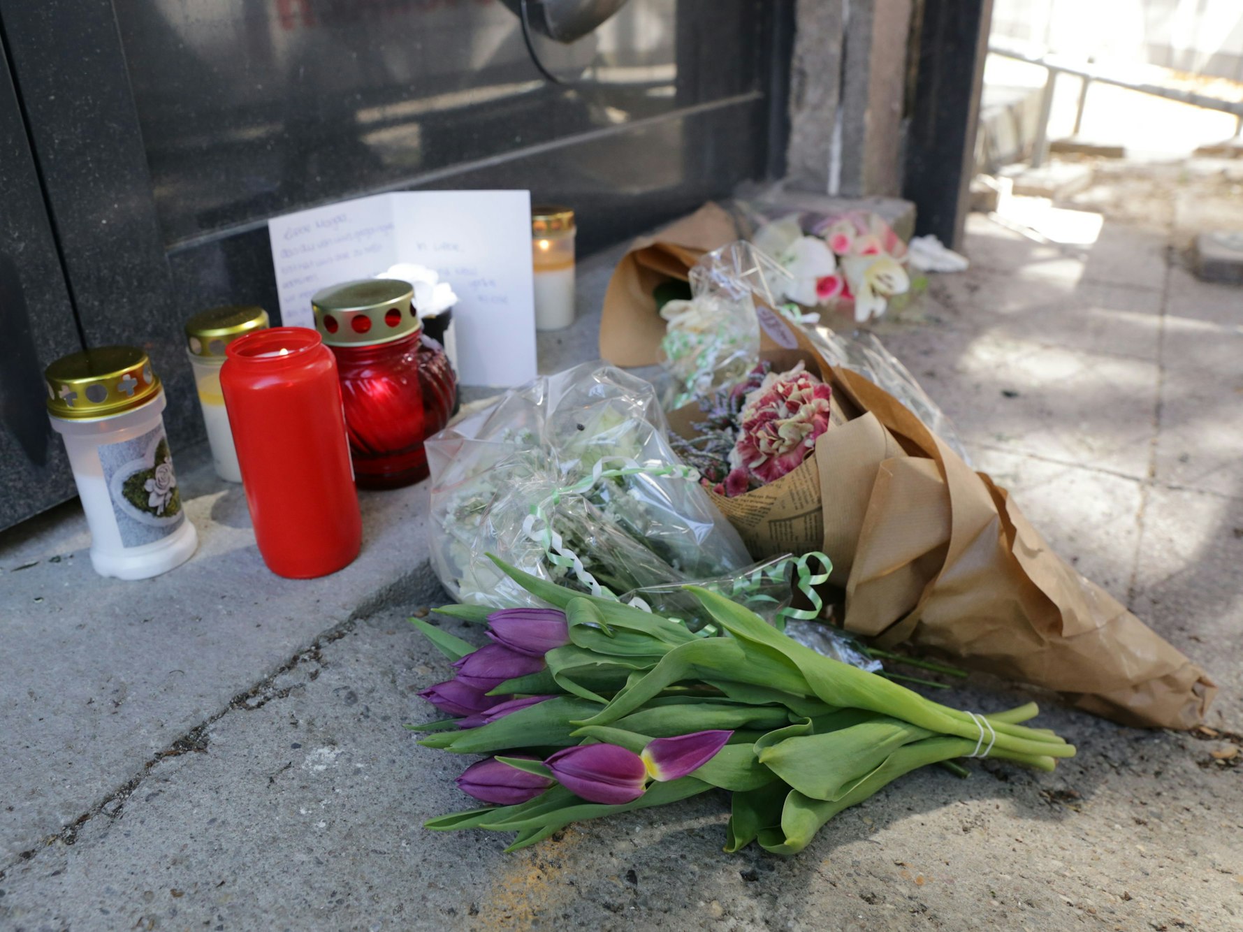 Vor der Filiale legten Kollegen und Kolleginnen der getöteten Frau Blumen, Kerzen und eine Karte mit einem letzten Gruß nieder.