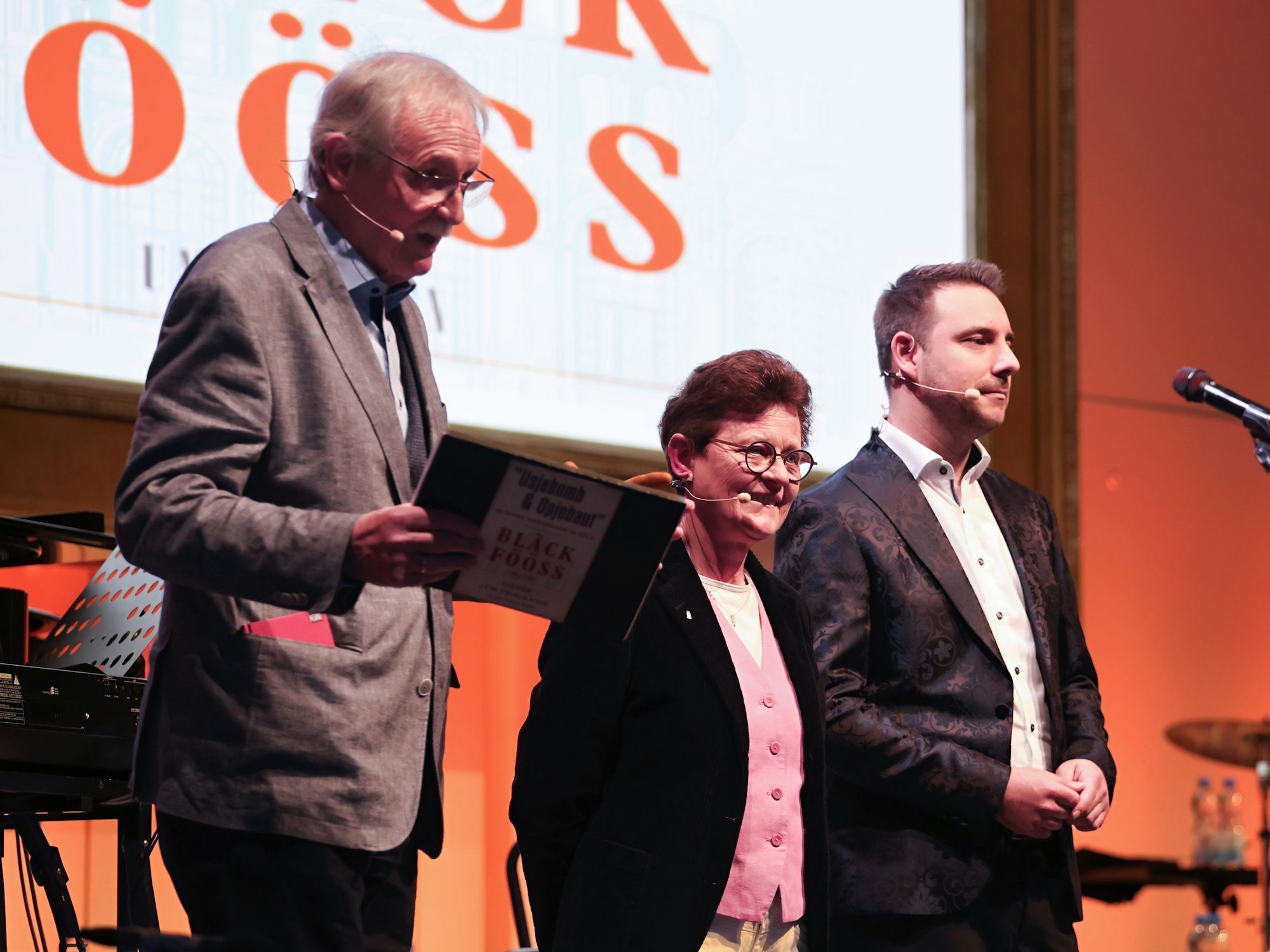 Wolfgang Oelsner, Monika Salchert und Stephan Henseler stehen auf der Bühne.