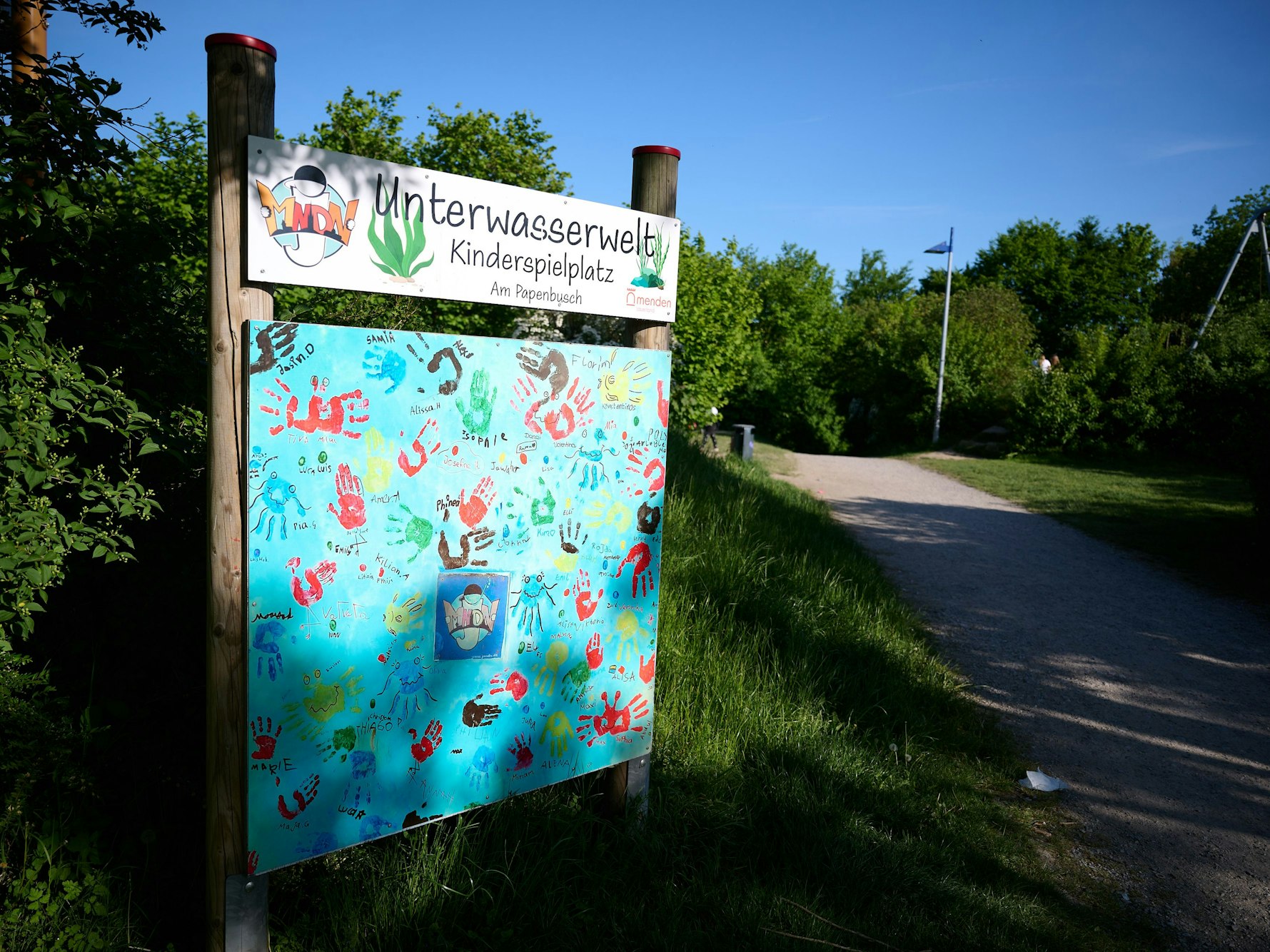 Ein Schild mit der Aufschrift Unterwasserwelt – Kinderspielplatz steht an einem der Zugänge zum Spielplatz im Sauerland. Auf dem Spielplatz soll in der Nacht ein 17-Jähriger einen 14-Jährigen erstochen haben.