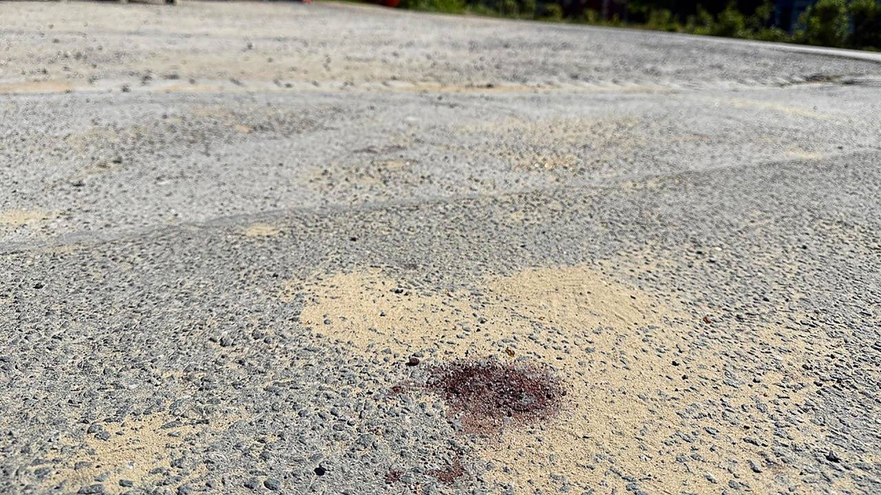 Ein Blutfleck ist auf dem Asphalt am Tatort in Menden im Sauerland zu sehen. Nach dem gewaltsamen Tod eines 14-Jährigen ermittelt die Polizei.
