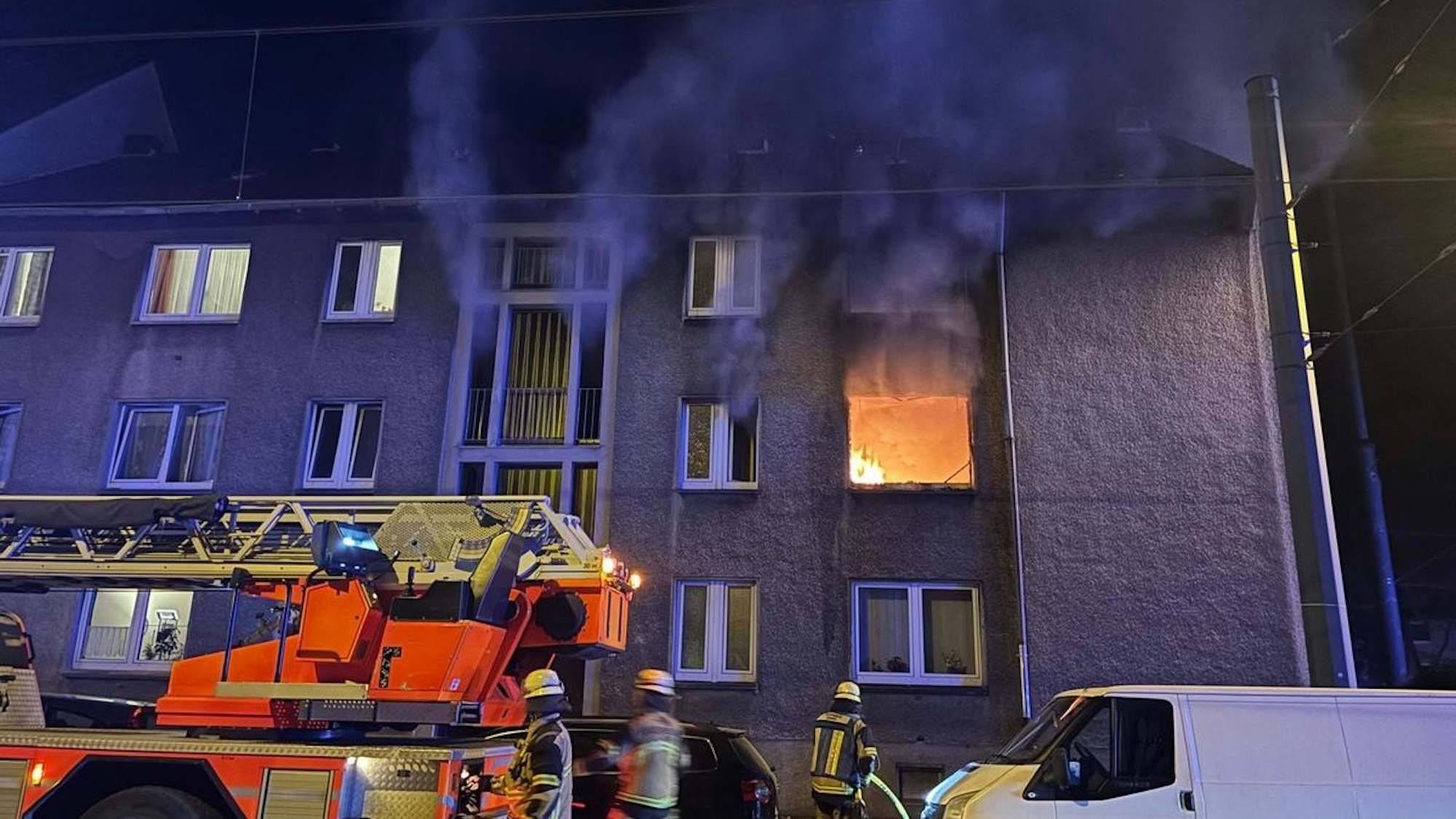 Nächtlicher Wohnungsbrand in einem Mehrfamilienhaus in Essen-Karnap. Feuerwehrleute im Einsatz bei der Brandbekämpfung.