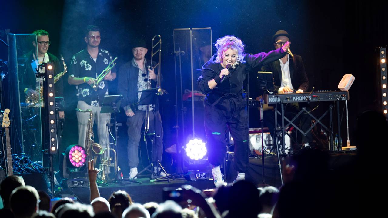 Die Musikband Kempes Feinest beim Konzert im Gloria. Nici Kempermann springt und hüpft.