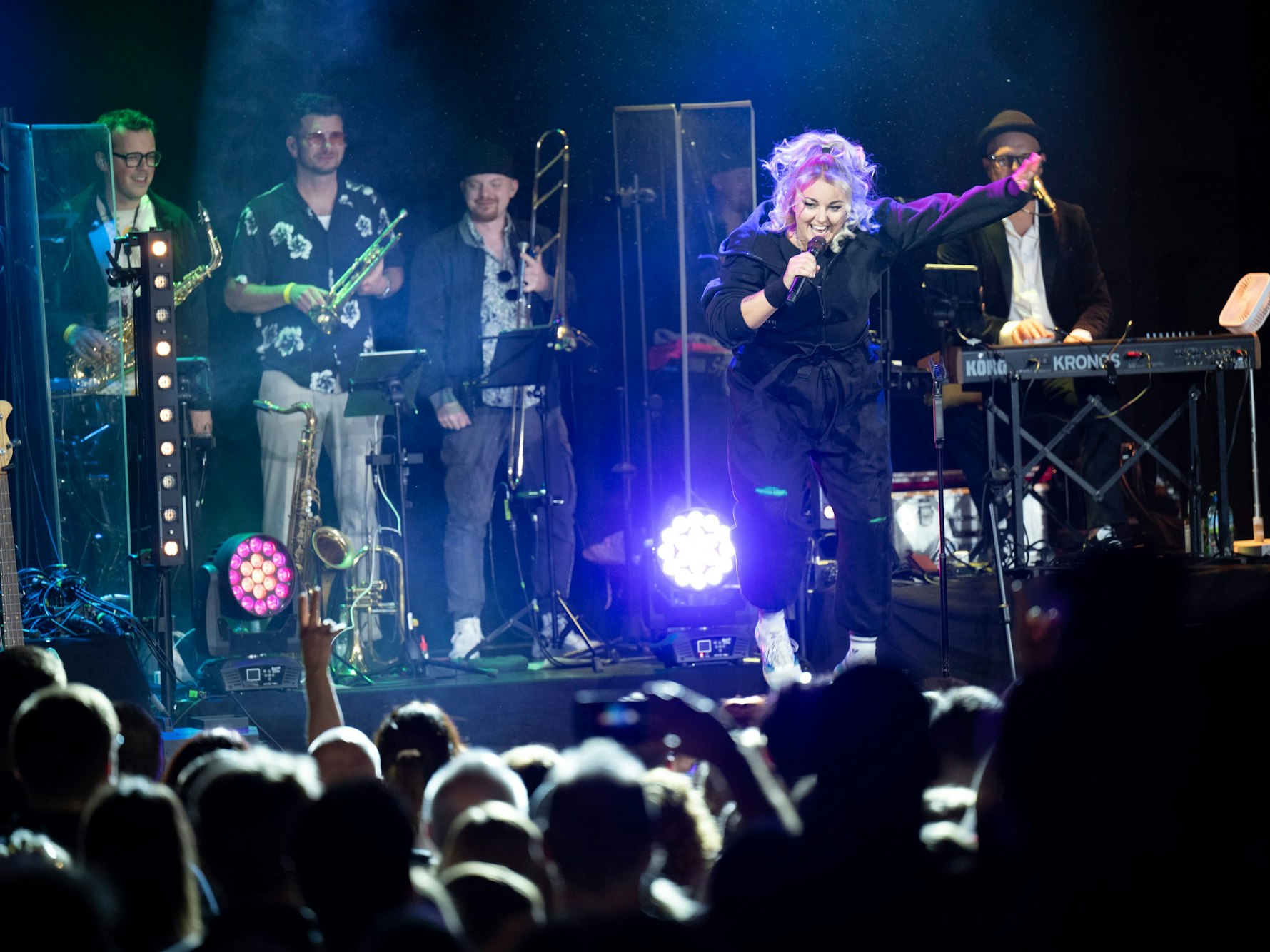 Die Musikband Kempes Feinest beim Konzert im Gloria. Nici Kempermann springt und hüpft.