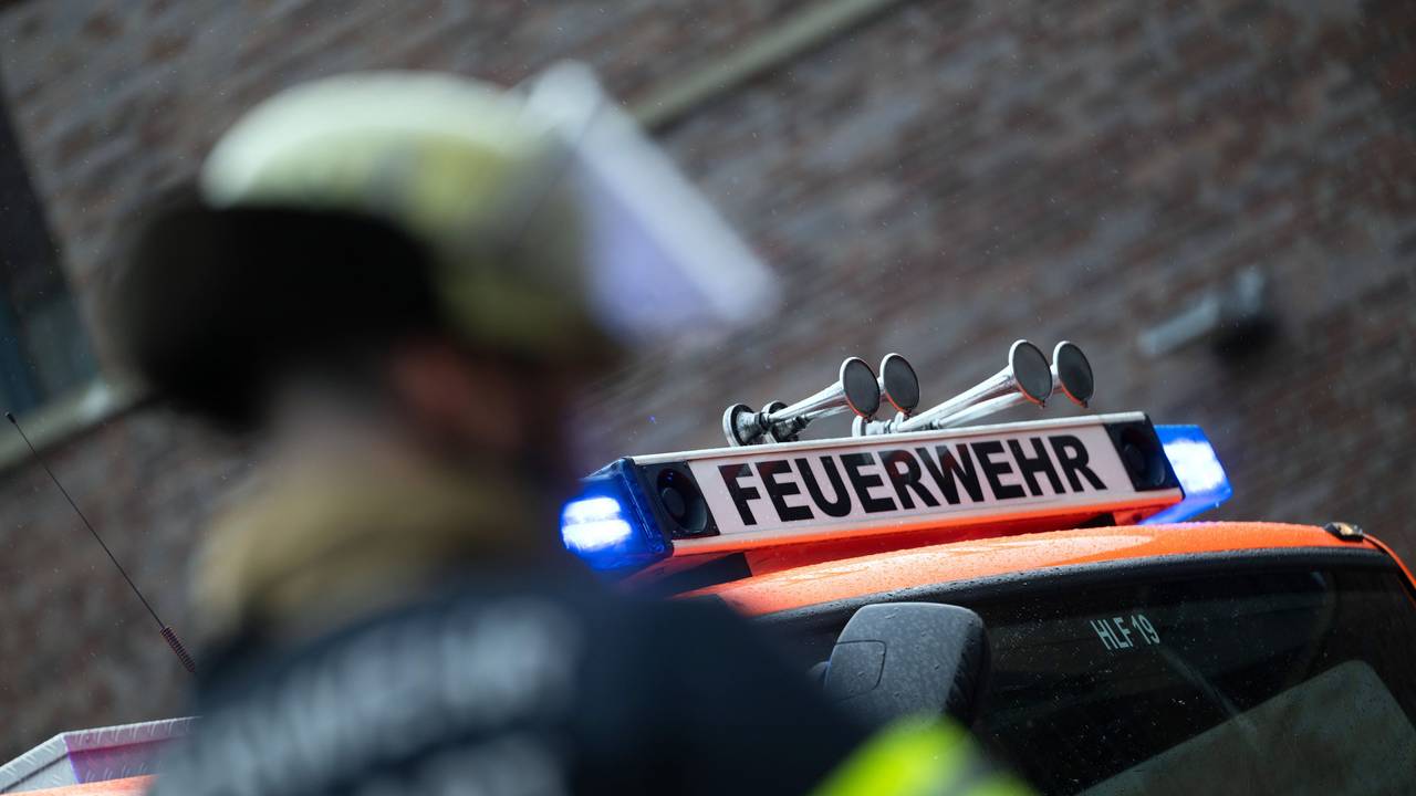 Eine Einsatzkraft der Feuerwehr steht vor einem Einsatzfahrzeug (gestellte Szene).