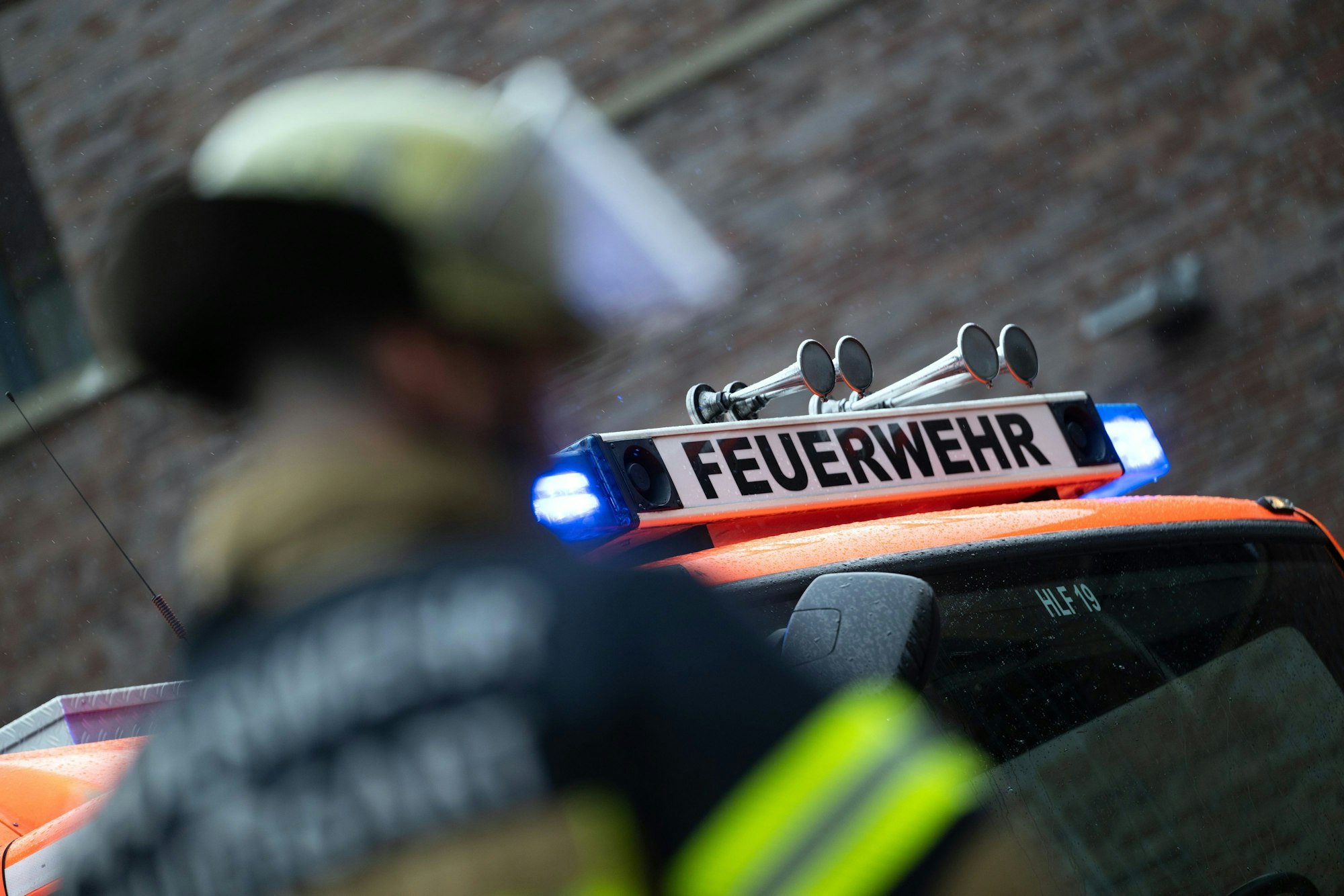 Eine Einsatzkraft der Feuerwehr steht vor einem Einsatzfahrzeug (gestellte Szene).