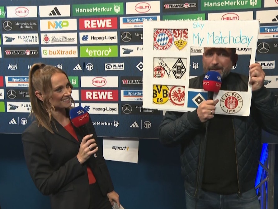 Torsten Mattuschka stellt mit einer Papptafel das neue Sky-Format „My Matchday“ vor. Moderatorin Nele Ocik steht daneben.