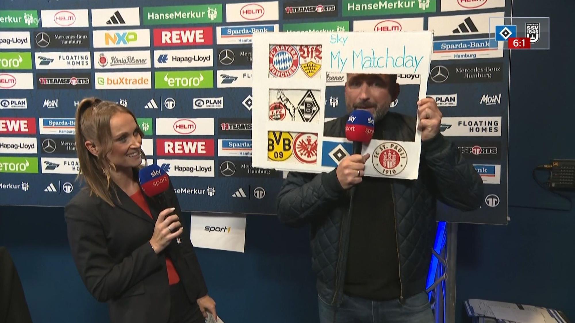 Torsten Mattuschka stellt mit einer Papptafel das neue Sky-Format „My Matchday“ vor. Moderatorin Nele Ocik steht daneben.