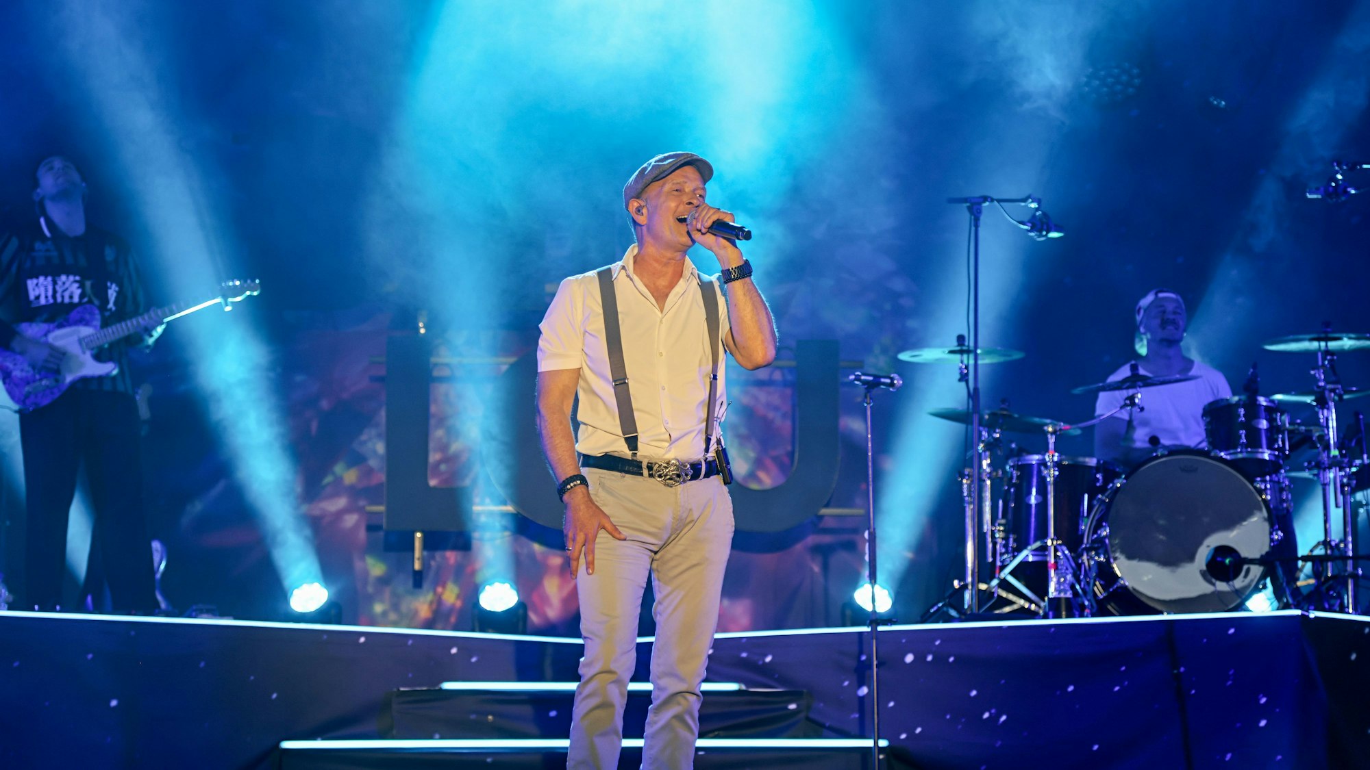 Frank Reudenbach steht auf der Bühne.