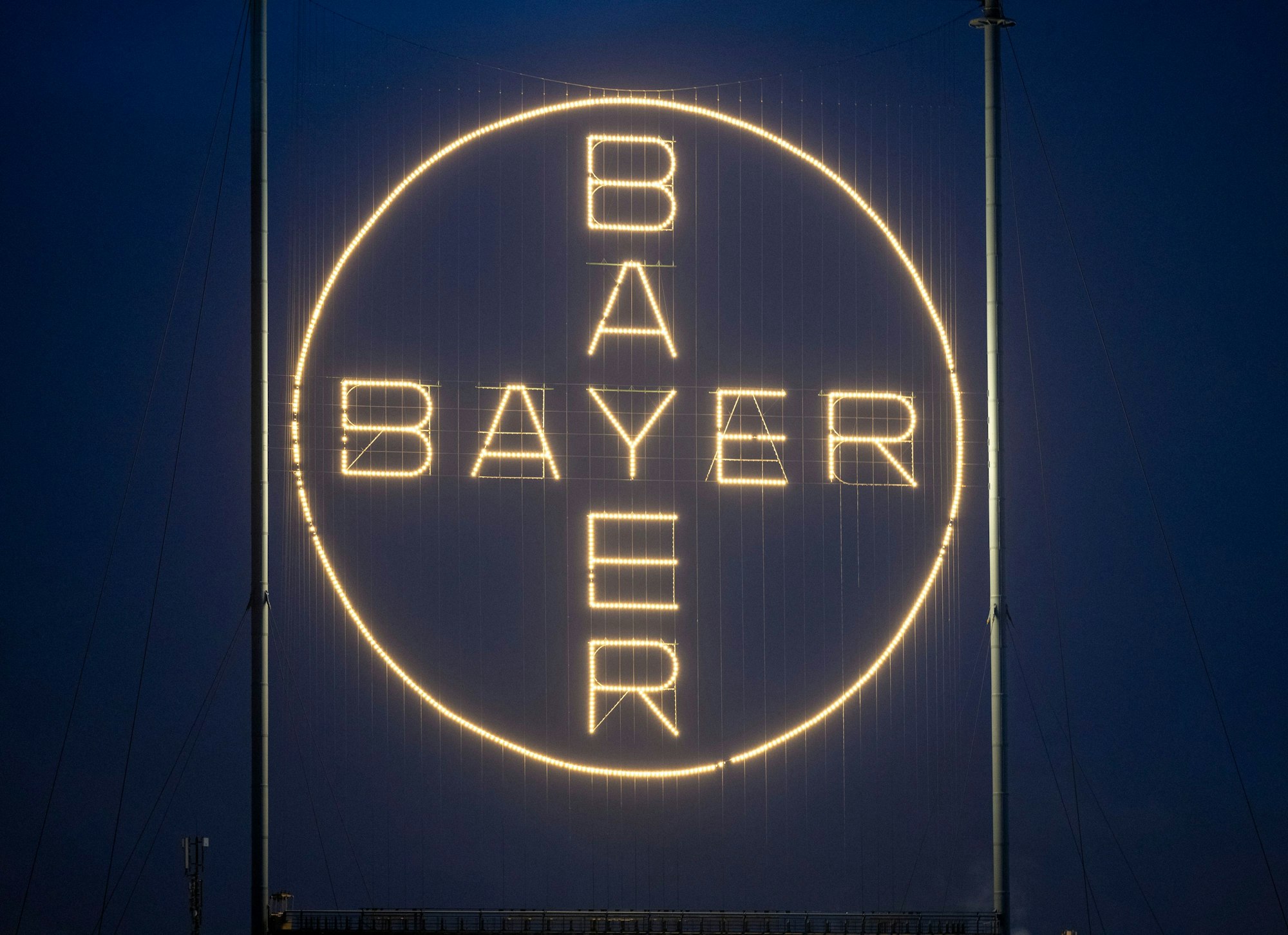 Das Bayerkreuz, das Logo des Unternehmens, leuchtet auf dem Werksgelände von Bayer in Leverkusen. Bayer gibt seinen Standort in Frankfurt auf.