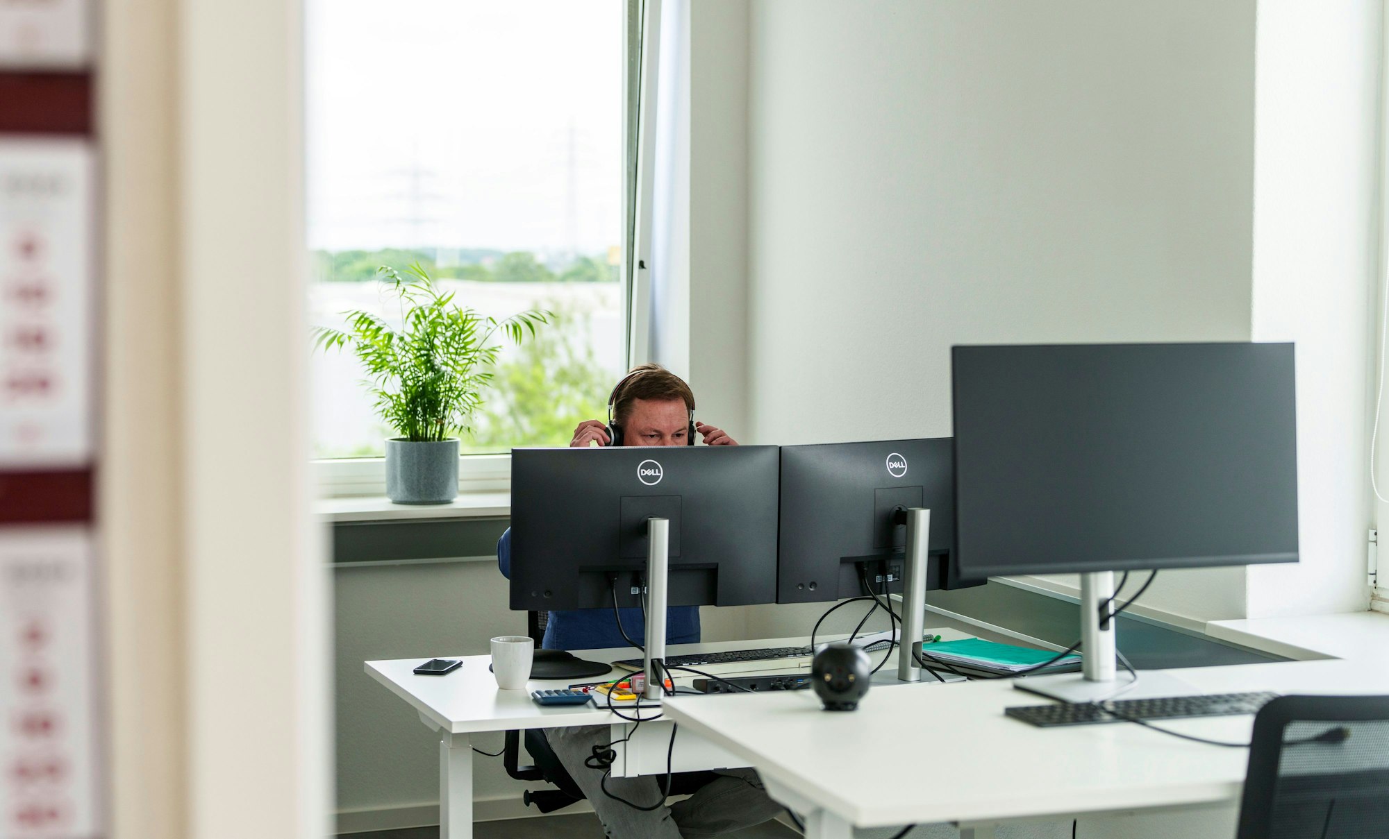 Ein Mann arbeitet in einem Coworking-Space in seinem Büro (Symbolbild). Wirtschaftsbosse fordern die Abschaffung von Feiertagen für mehr Produktivität in Deutschland.