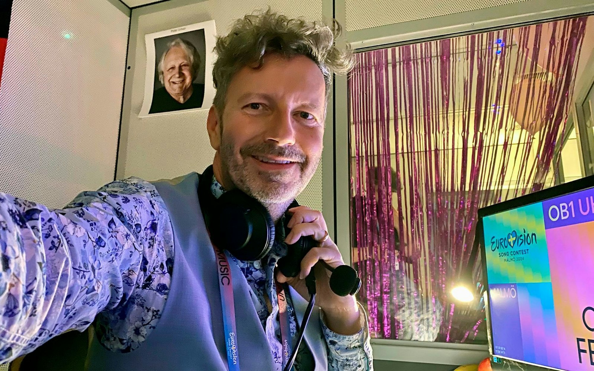 Sein Vorgänger Peter Urban hängt noch als Foto an der Wand. Trotzdem hat ESC-Kommentator Thorsten Schorn nach seinem Debüt 2024 nun schon den zweiten europäischen Gesangswettbewerb vor der Brust. Am Samstag, 17. Mai, kommentiert der 49-jährige Kölner sein zweites Finale. Schon am Dienstag und Mittwoch ist er bei den Halbfinals zu hören. (Bild: NDR / Thorsten Schorn)