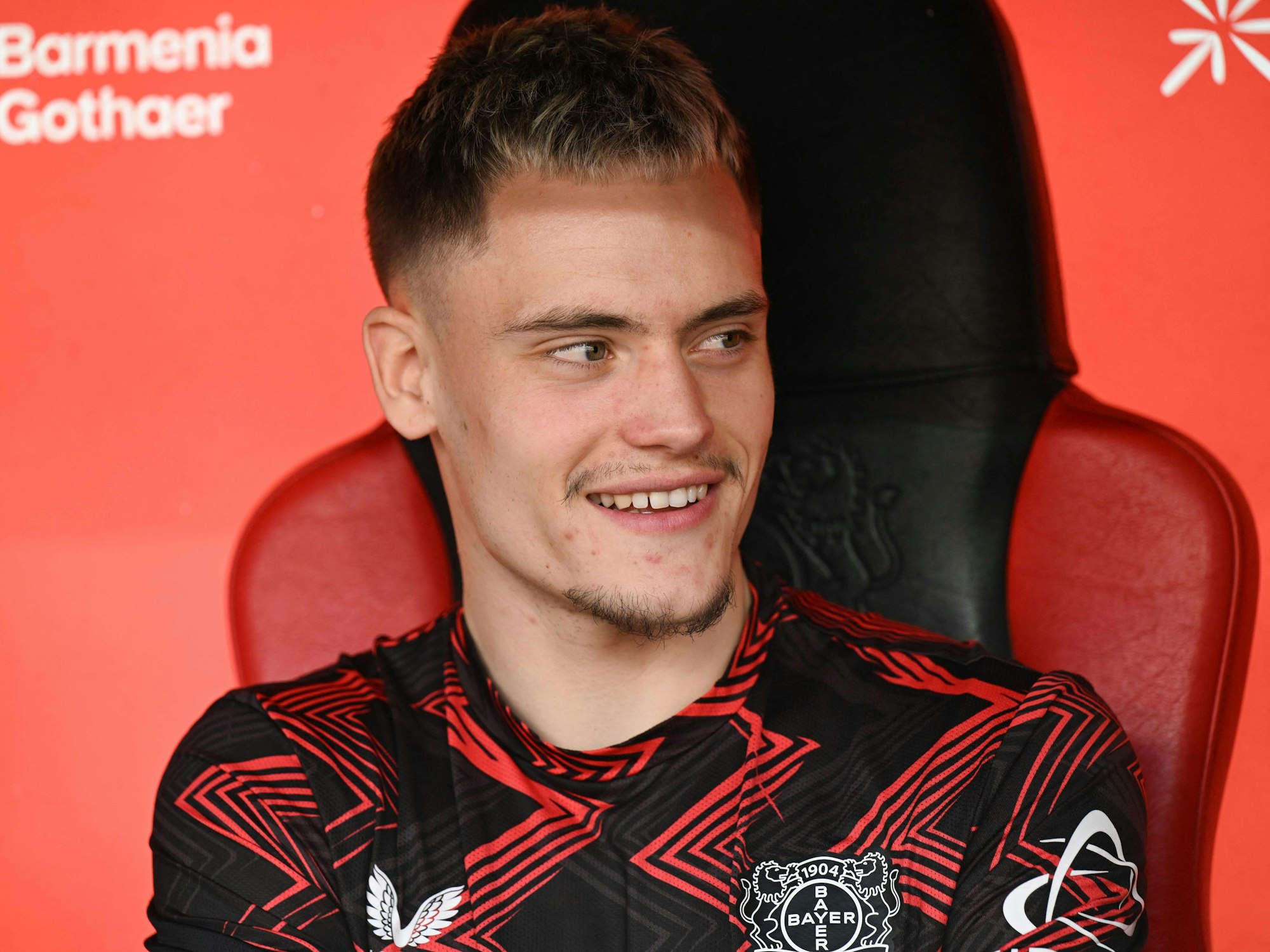 Florian Wirtz lächelt auf der Bank von Bayer Leverkusen
