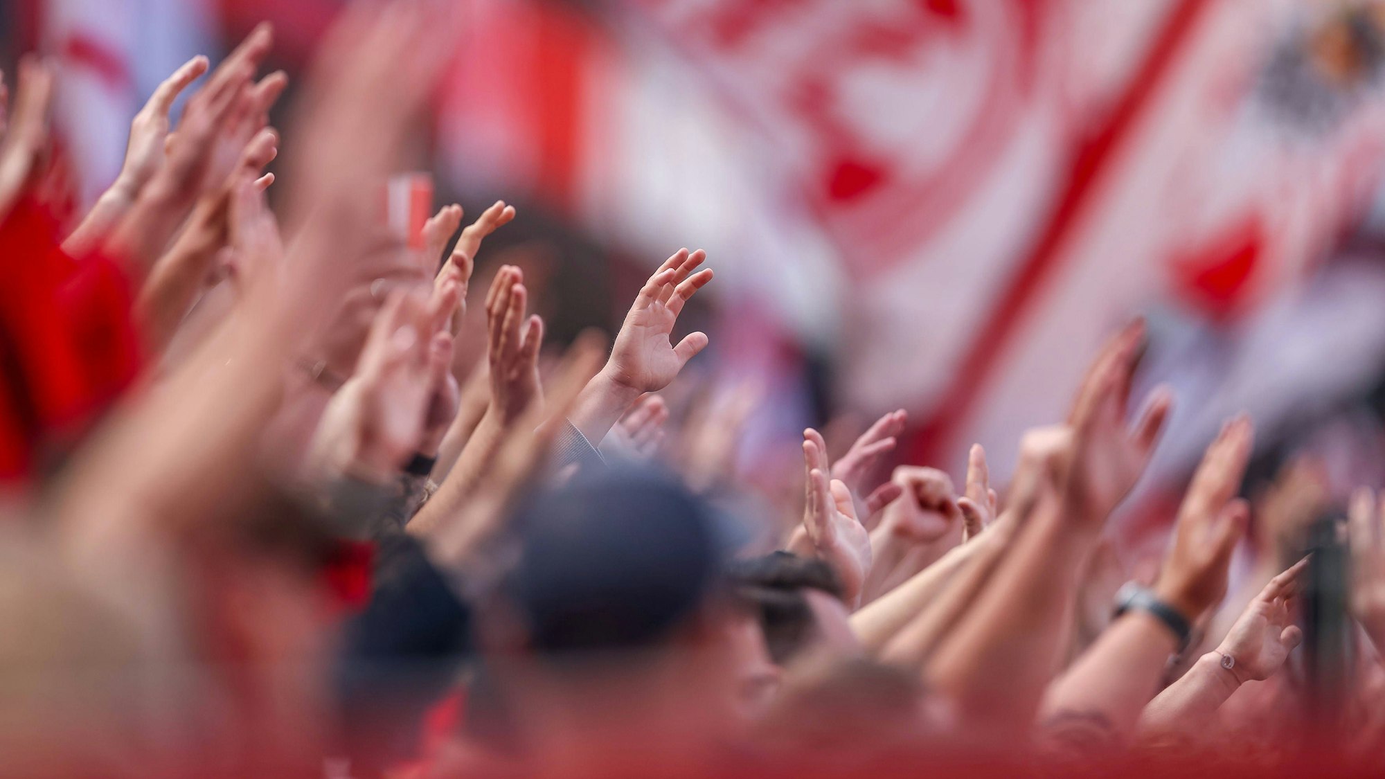 FC-Fans halten ihre Hände in die Luft.