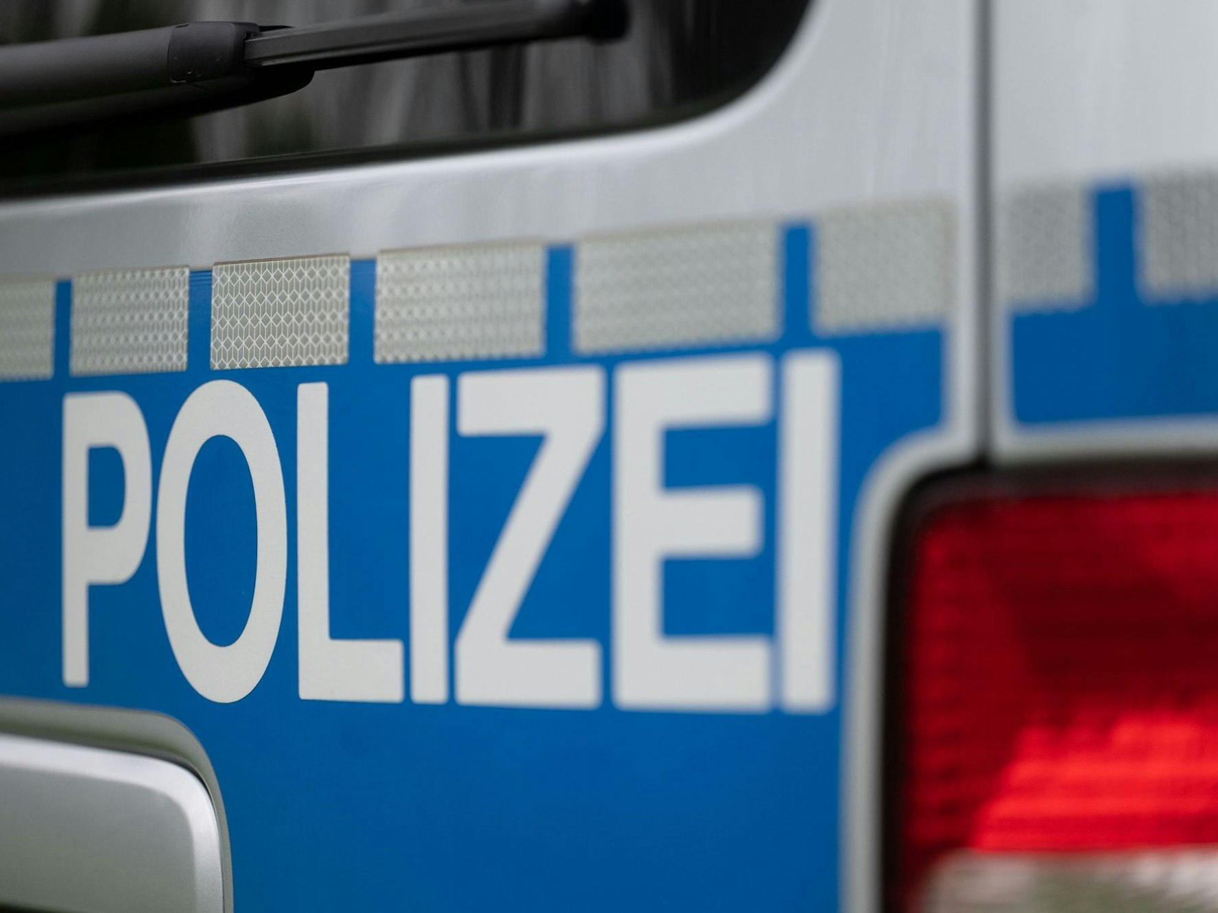 Der Schriftzug Polizei an einem Streifenwagen.