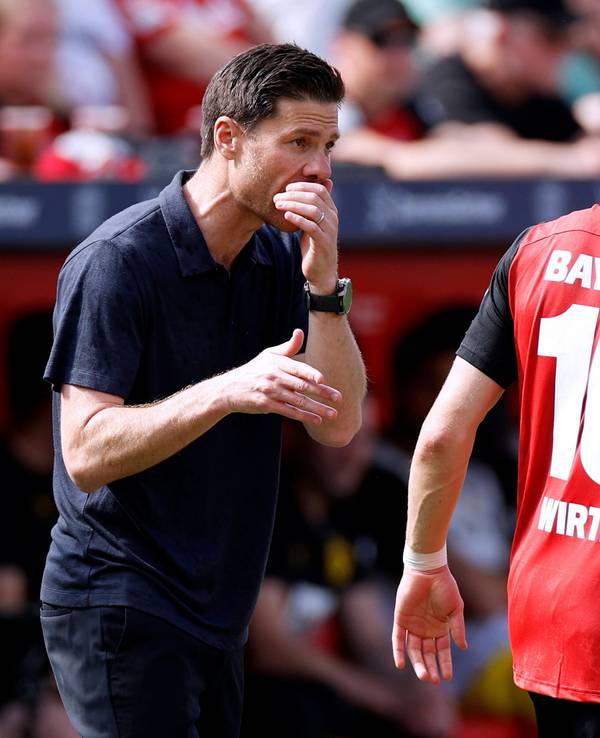Xabi Alonso gibt Florian Wirtz hinter vorgehaltener Hand taktische Anweisungen.