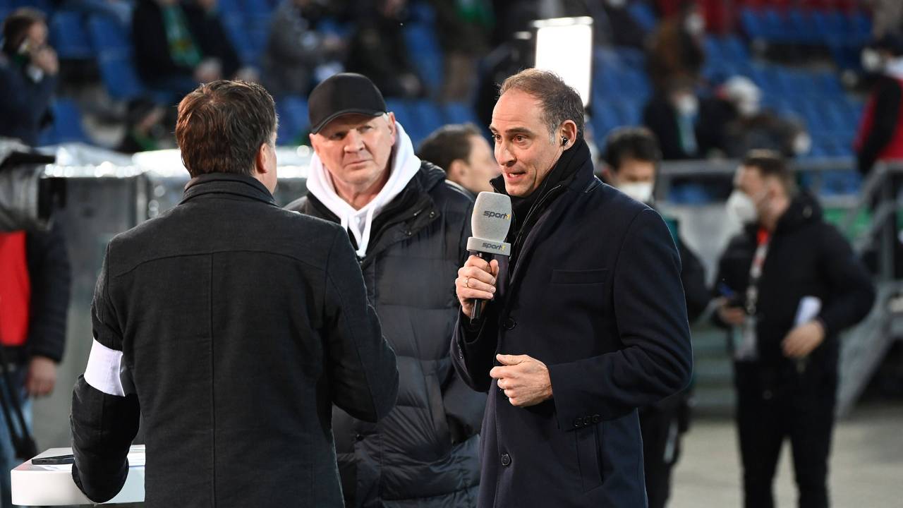 Sport1-Experte Stefan Effenberg steht bei einem Interview mit Oliver Mintzlaff im Hintergrunf.