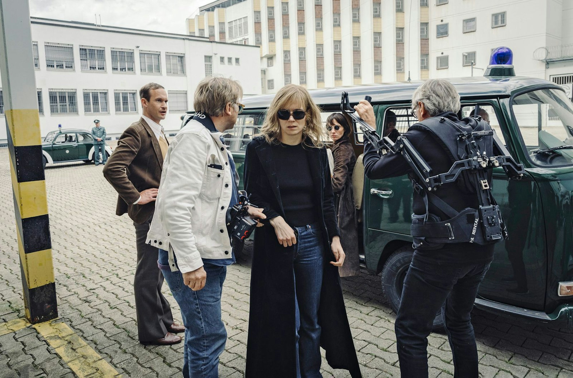 Autor und Regisseur Niki Stein (zweiter von links) bereitet eine Szene seines Films „Stammheim - Zeit des Terrors“ vor. Vorn im Bild: Schauspielerin Lilith Stangenberg als RAF-Terroristin Gudrun Ensslin. (Bild: SWR/Hendrik Heiden)