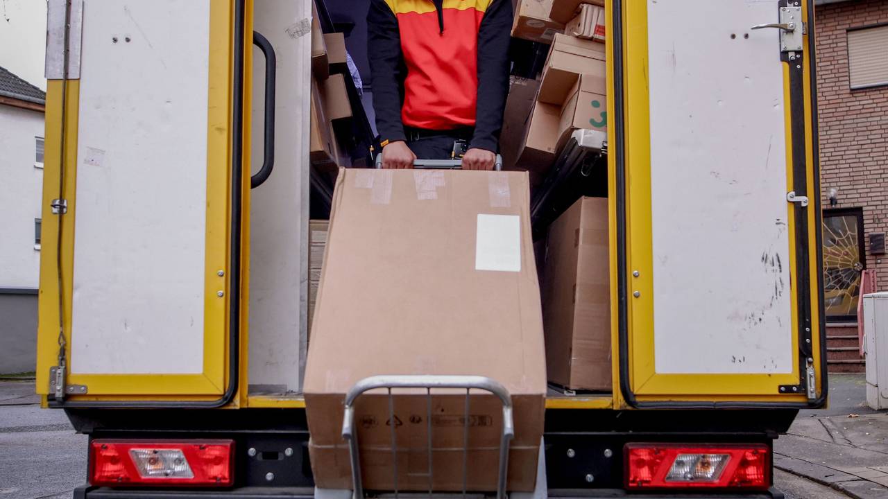 Ein DHL-Mitarbeitet in Köln bei der Zustellung.