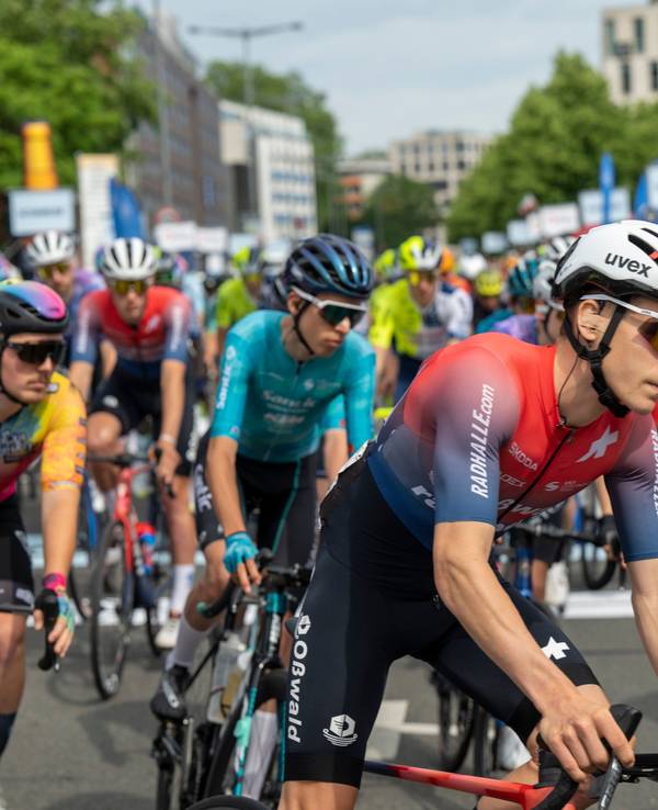 Rennradfahrer drängen sich auf einer Straße.
