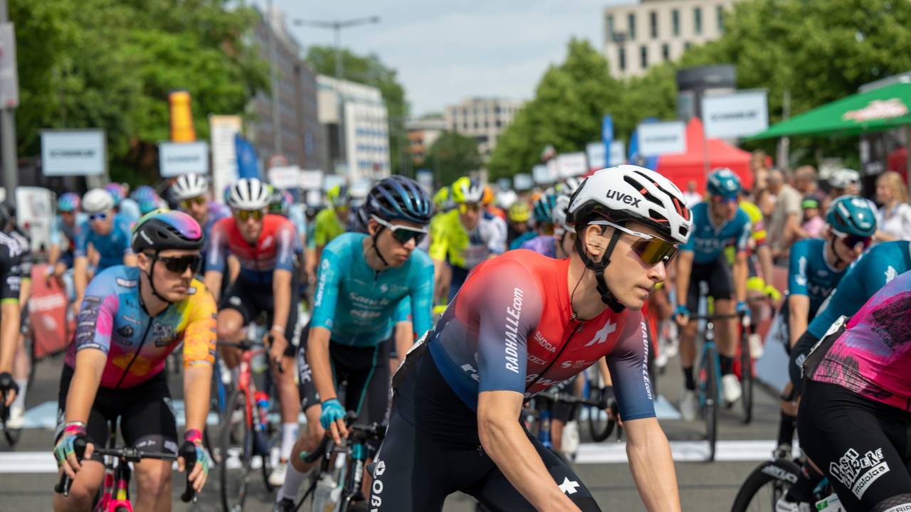 Rennradfahrer drängen sich auf einer Straße.