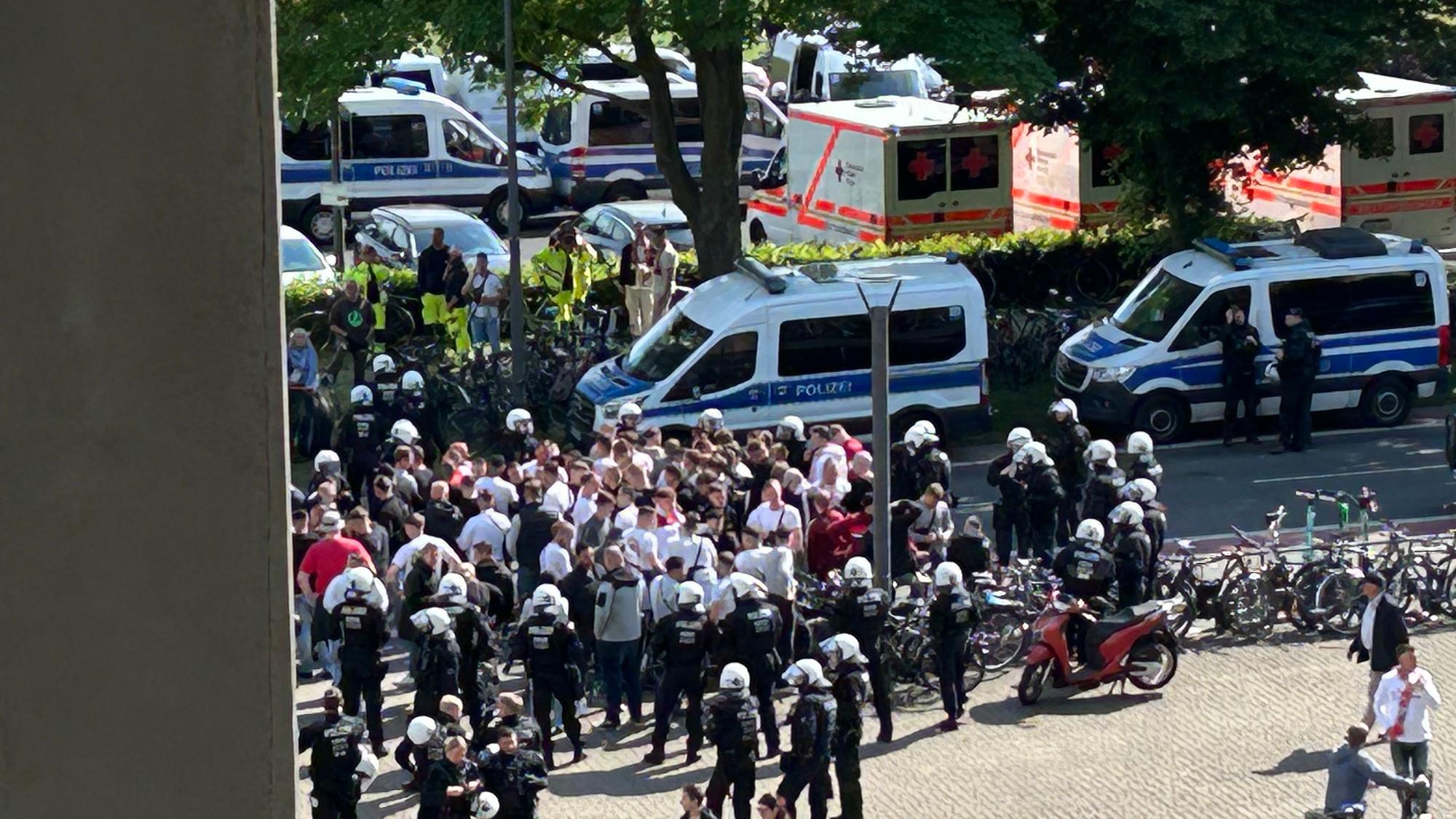 Während das Spiel läuft, stehen draußen Fans, die nicht reingekommen sind, die Polizei ist im Einsatz.