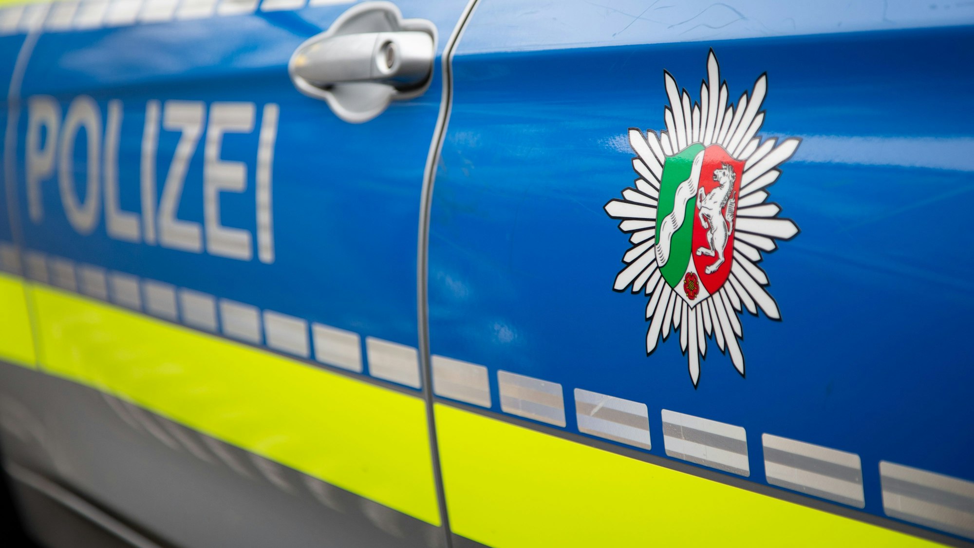 Emblem der Polizei NRW an einem Polizeiauto.