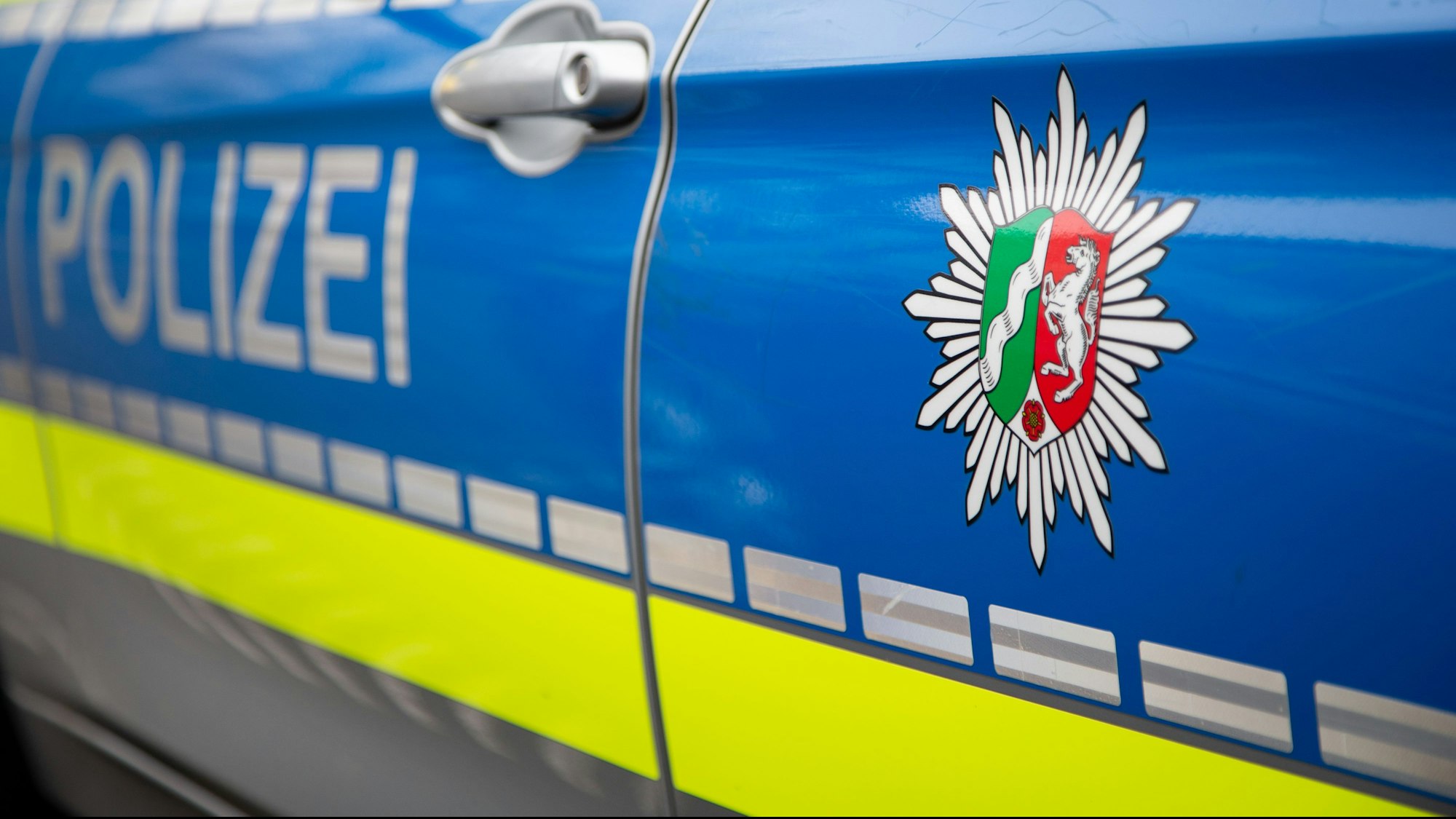 Blick auf ein Emblem der Polizei in NRW an einem Polizeiauto.