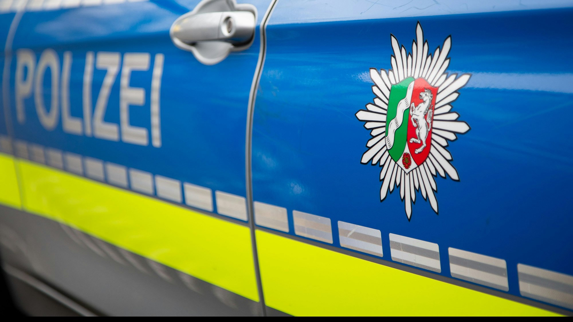 Emblem der Polizei NRW an einem Polizeiauto.
