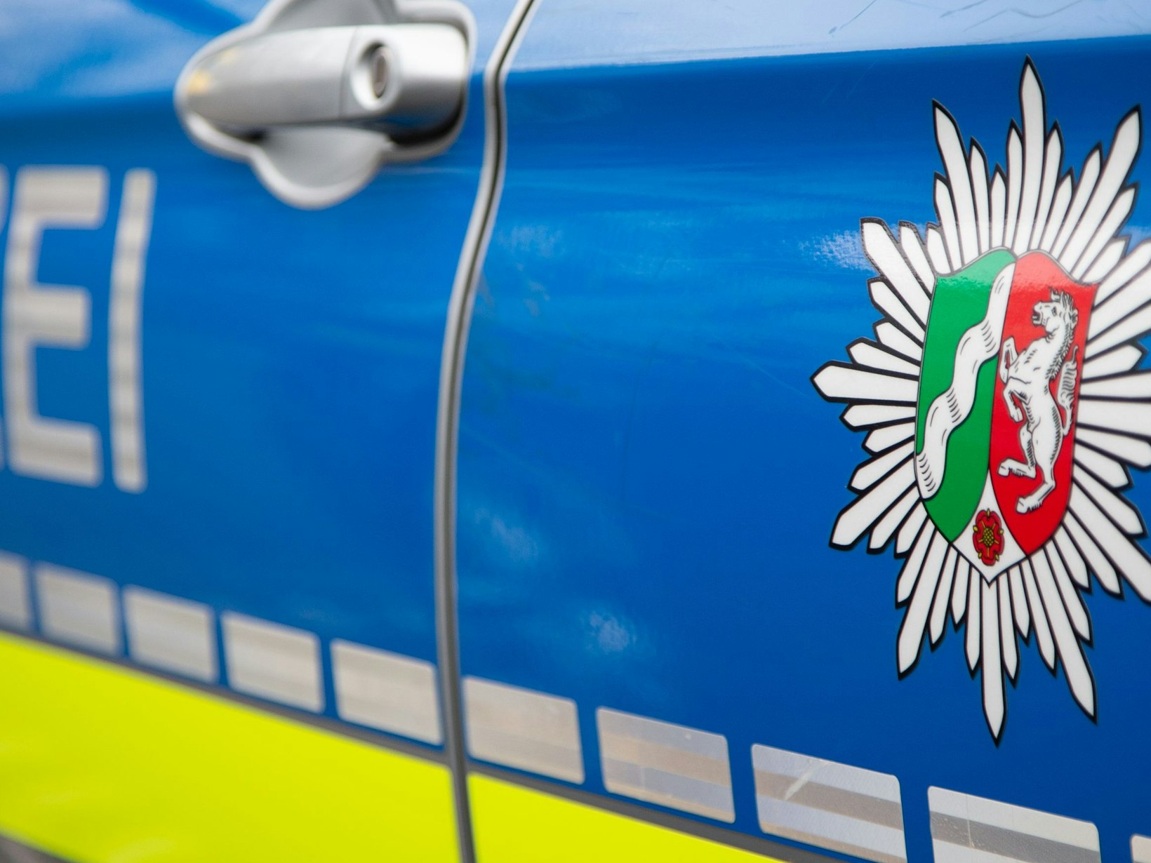 Emblem der Polizei NRW an einem Polizeiauto.