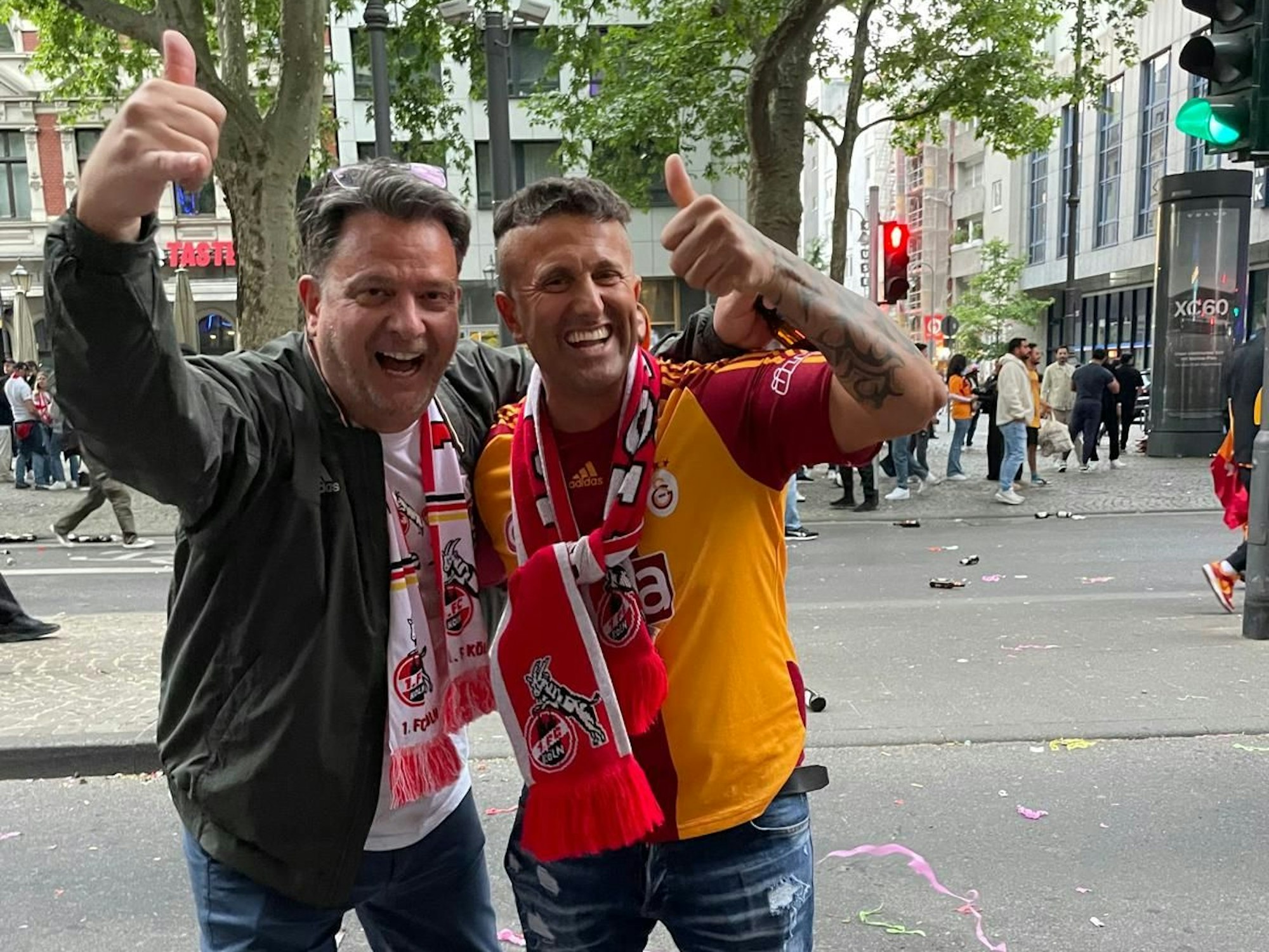 Zwei Fans des 1. FC Köln und Galatasaray feiern am 18. Mai 2025 gemeinsam auf den Kölner Ringen.