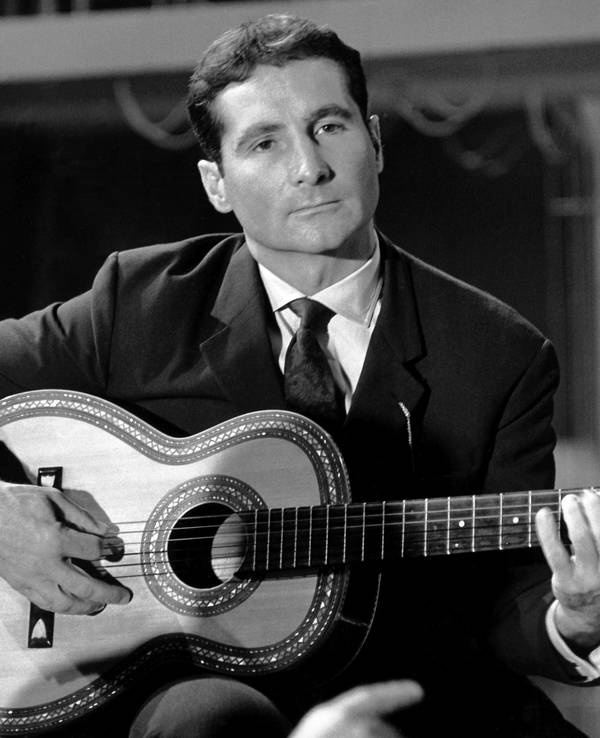 Der Sänger Freddy Quinn spielt auf der Gitarre bei einem Auftritt (undatierte Aufnahme).