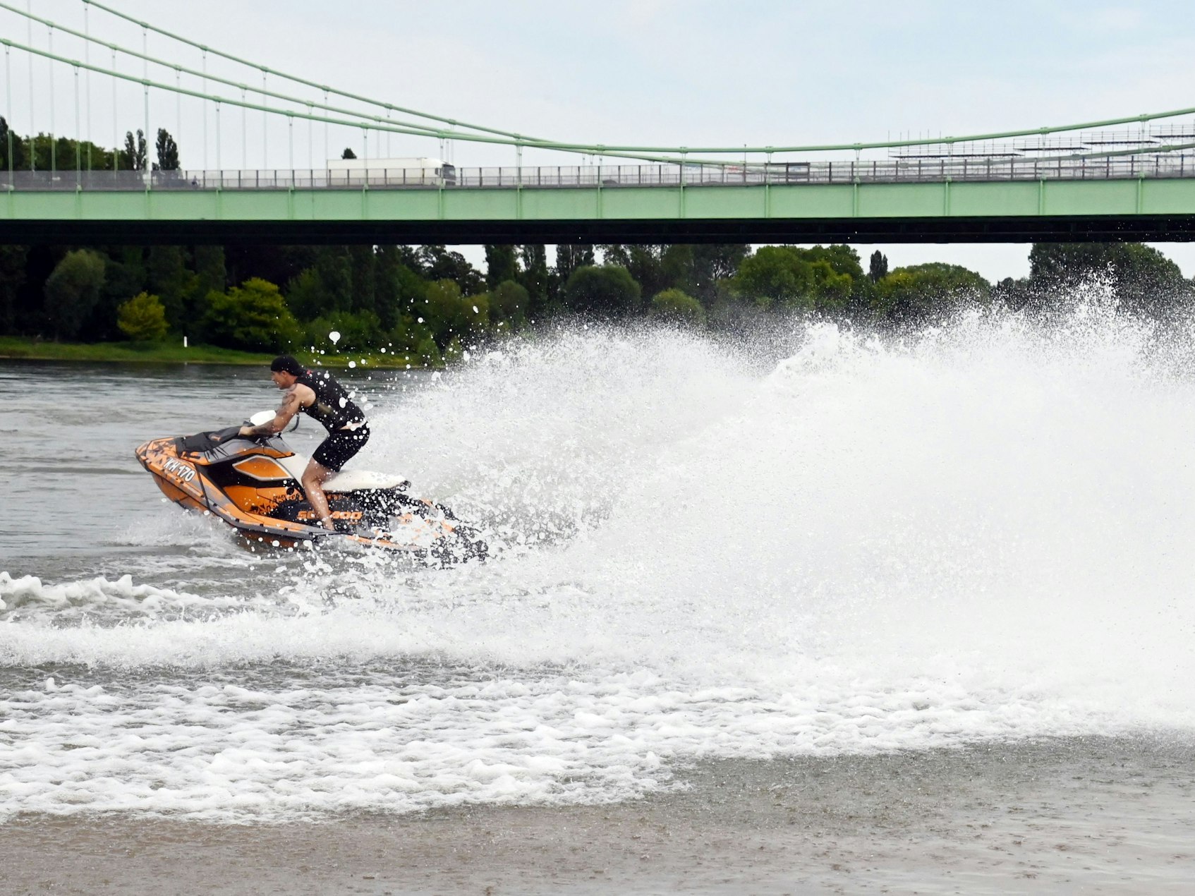 15.07.2024 Köln. Das Thema Wasser in verschiedenen Motiven. Ein Jetskifahrer dreht seine Runden unterhelb der Rodenkirchener Brücke. Der Mann war einverstanden mit den Fotos. Foto: Alexander Schwaiger