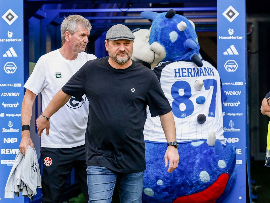 Steffen Baumgart und Friedhelm Funkel gehen am HSV-Maskottchen vorbei.