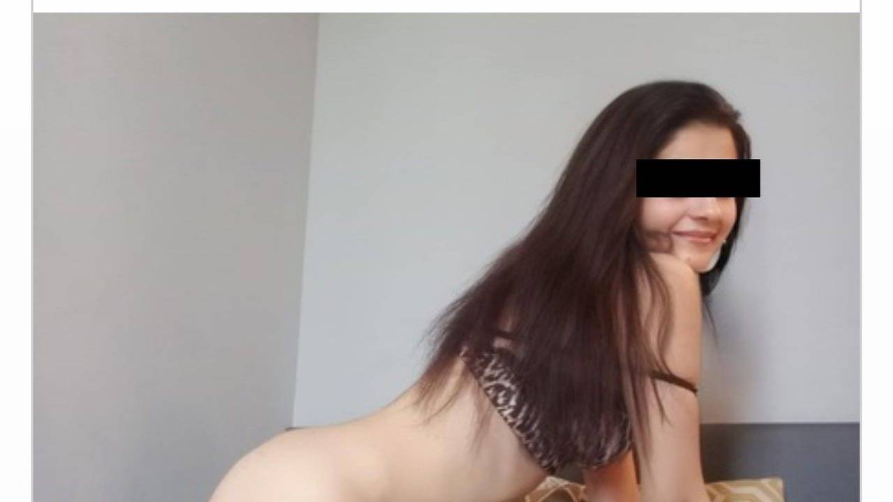 Eine halbnackte Frau posiert auf einem Bett.