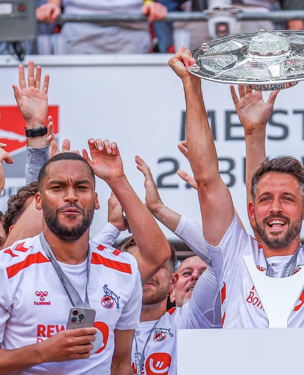 Mark Uth (M.) jubelt mit der Zweitliga-Schale in den Händen.