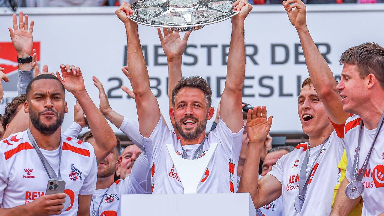 Mark Uth (M.) jubelt mit der Zweitliga-Schale in den Händen.