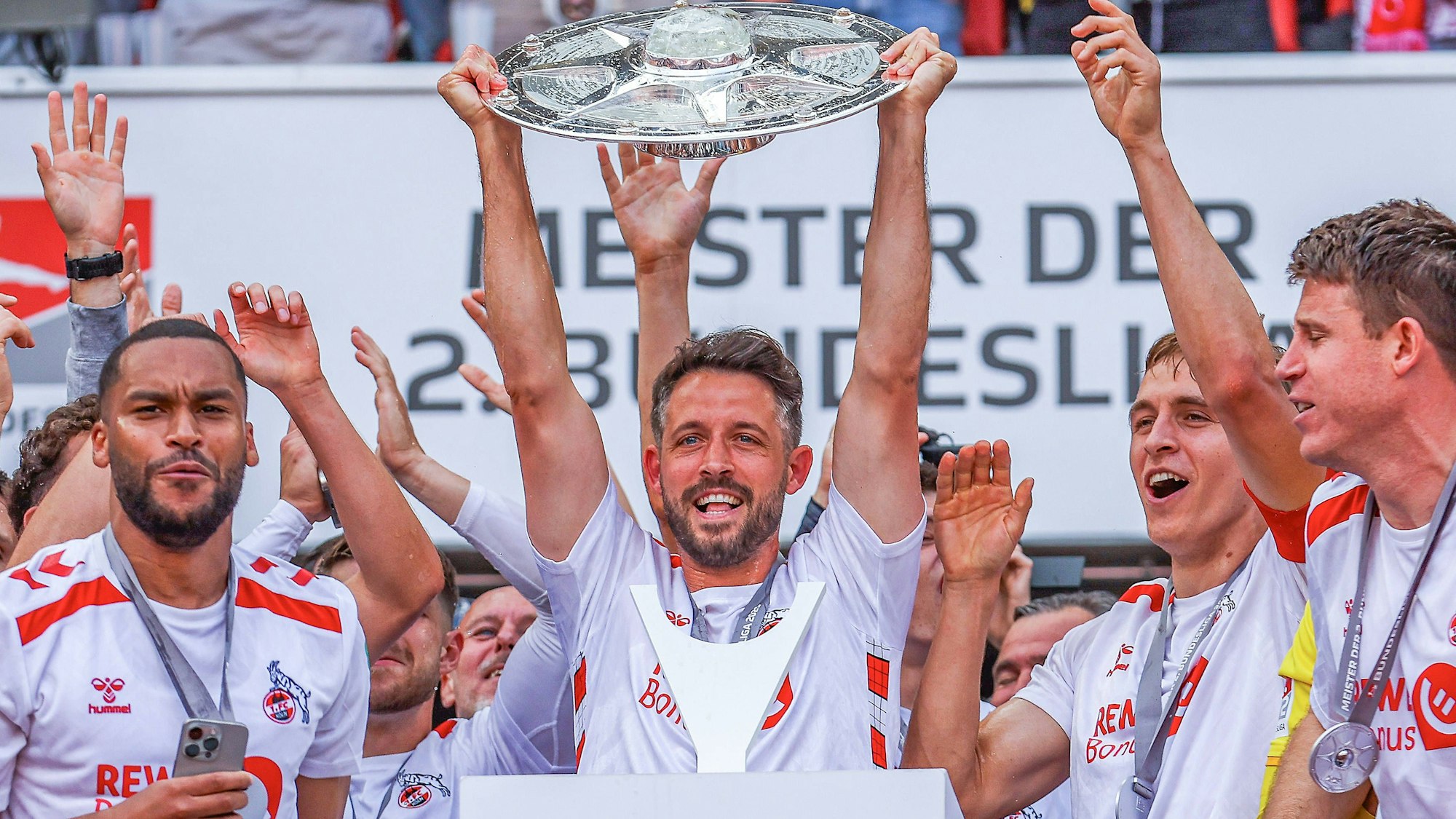 Mark Uth (M.) jubelt mit der Zweitliga-Schale in den Händen.