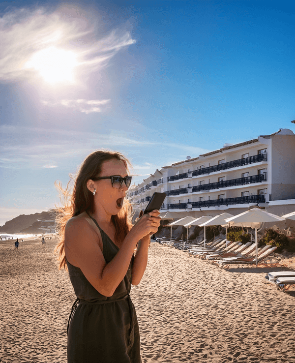 Das mit künstlicher Intelligenz erstellte Bild zeigt eine erschrockene Frau vor einer Anlage mit Ferienwohnungen in Spanien.