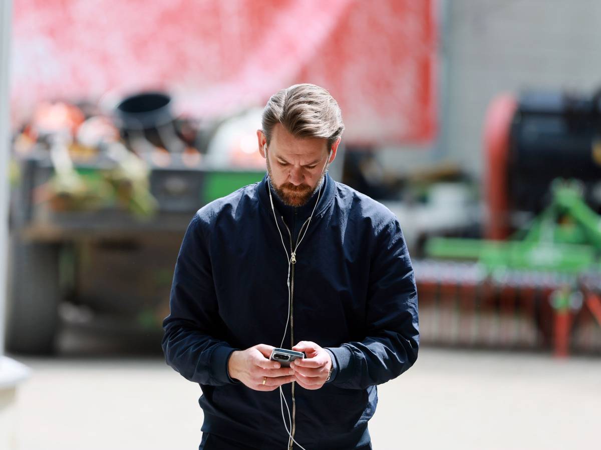 Thomas Kessler hat Kopfhörer in den Ohren und schaut auf sein Handy.