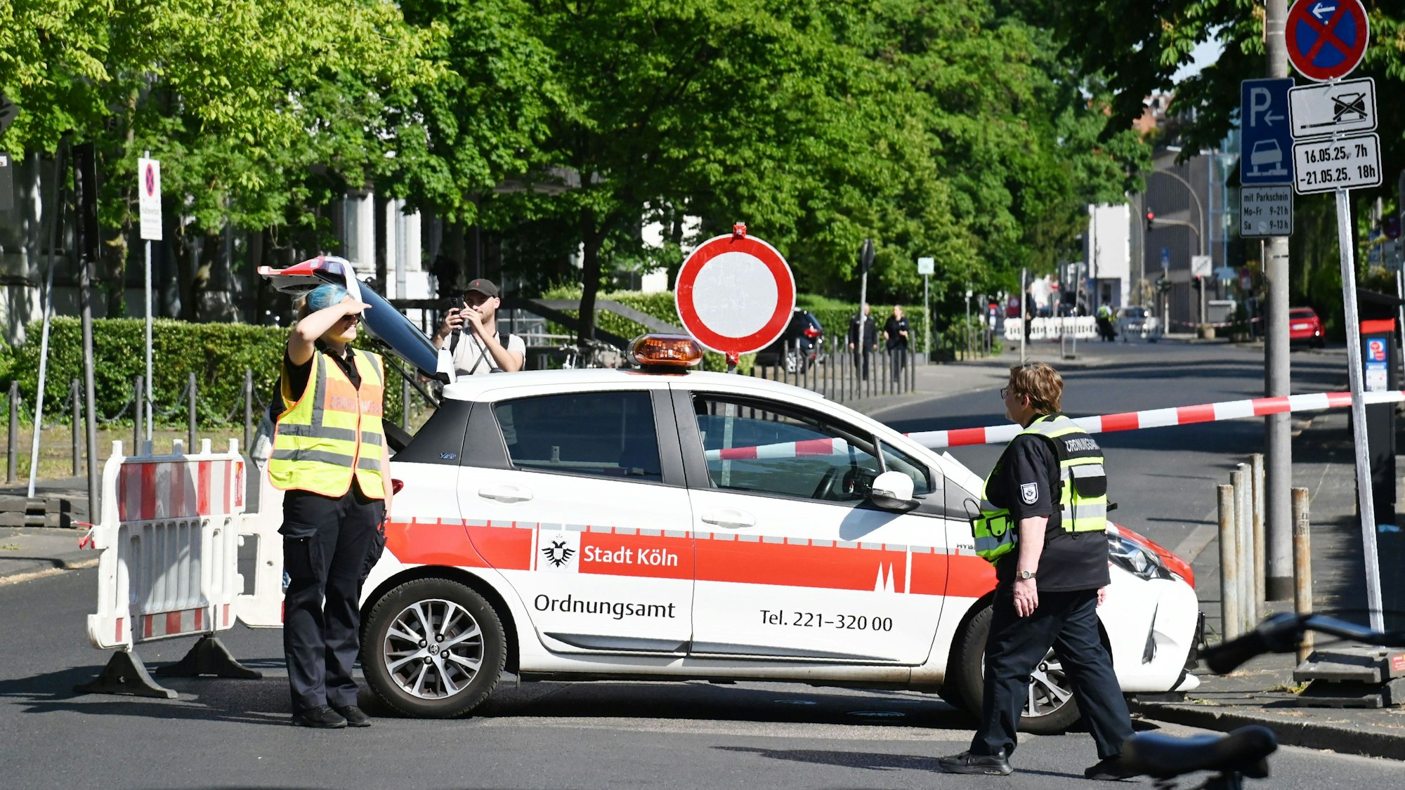 Ein Fahrzeug des Ordnungsamtes und zwei Einsatzkräfte stehen an einer Straßenabsperrung.