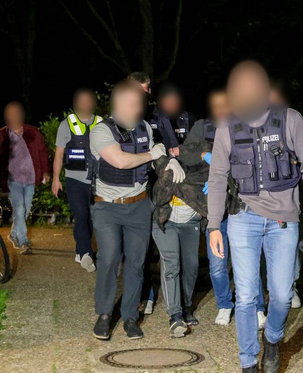 Einsatzkräfte der Polizei führen einen Tatverdächtigen nach seiner Festnahme in Heiligenhaus ab.