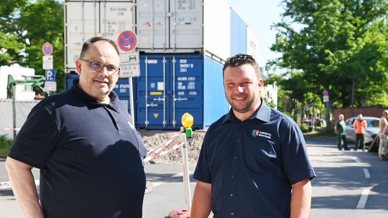 Zwei Männer stehen auf einer Straße.