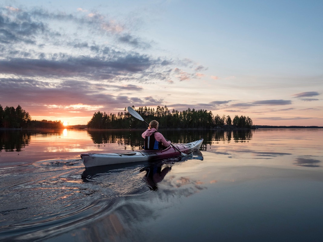 Kajakfahrt bei Sonnenuntergang im Saimaa-Seengebiet.