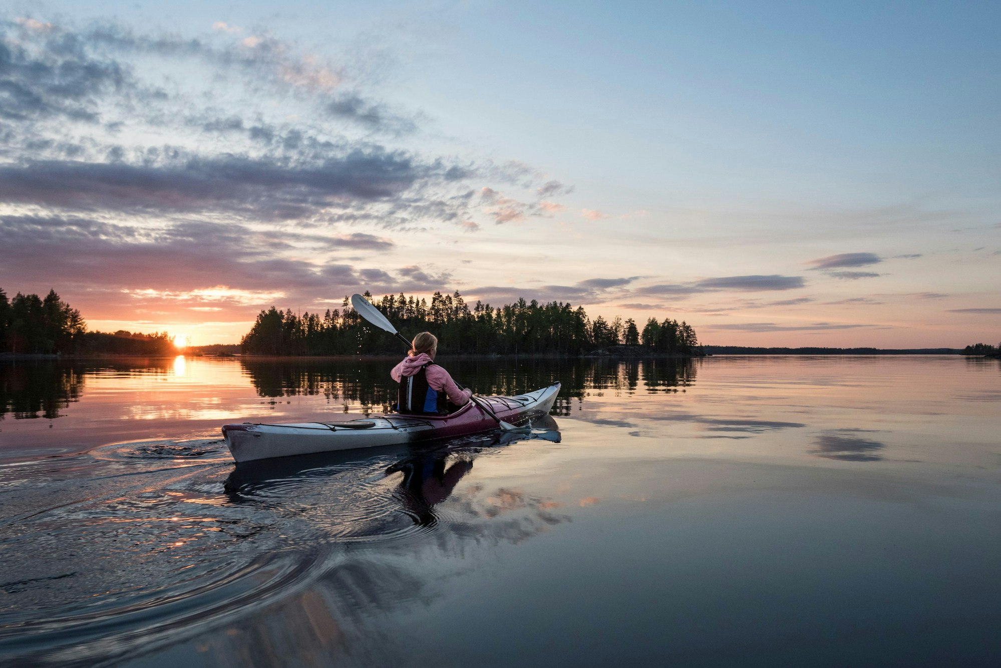 Kajakfahrt bei Sonnenuntergang im Saimaa-Seengebiet.