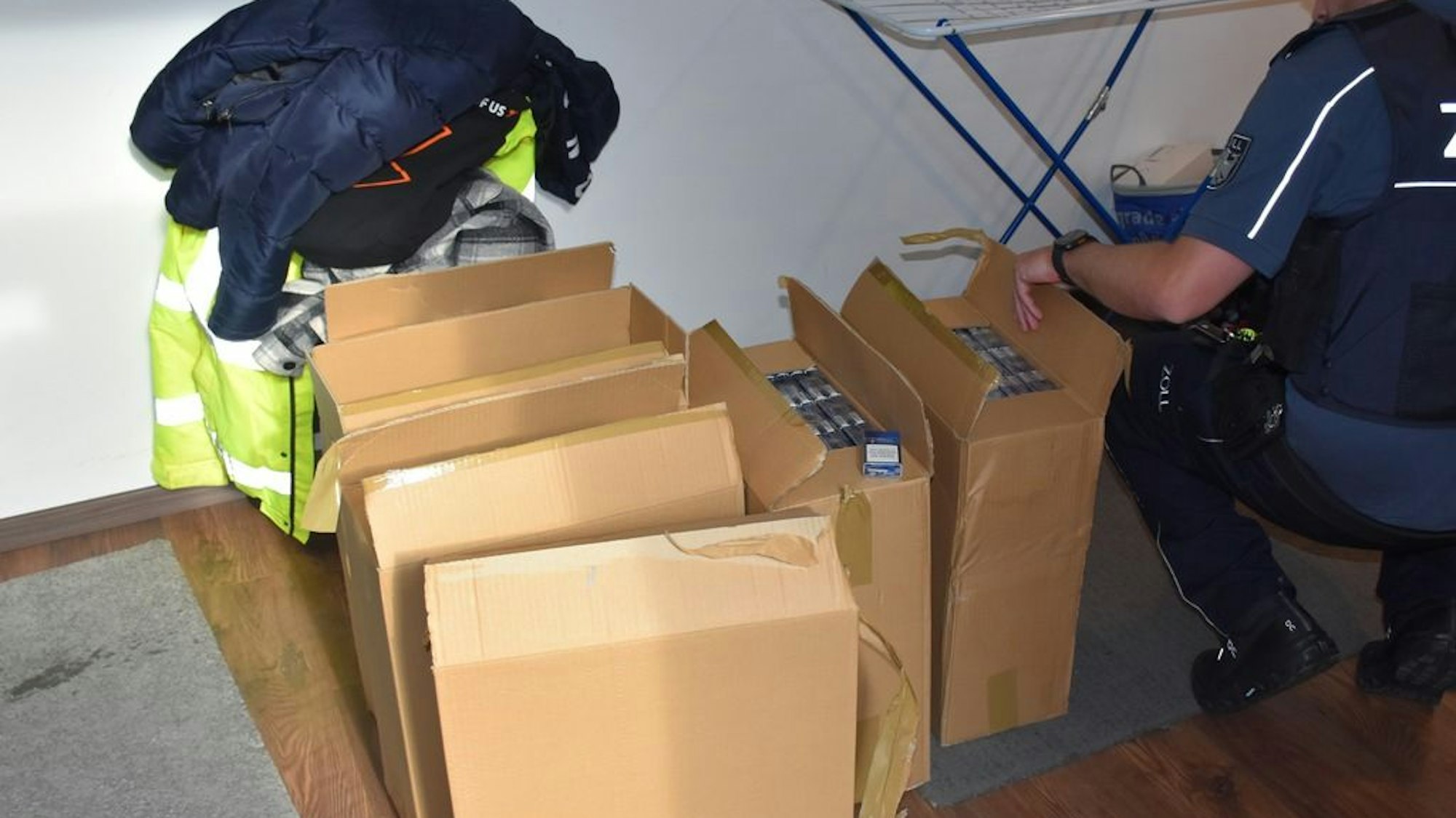 Zollbeamte bei der Sicherstellung unversteuerte Zigaretten während einer Durchsuchungsaktion gegen Schwarzarbeit auf dem Bau in Krefeld.