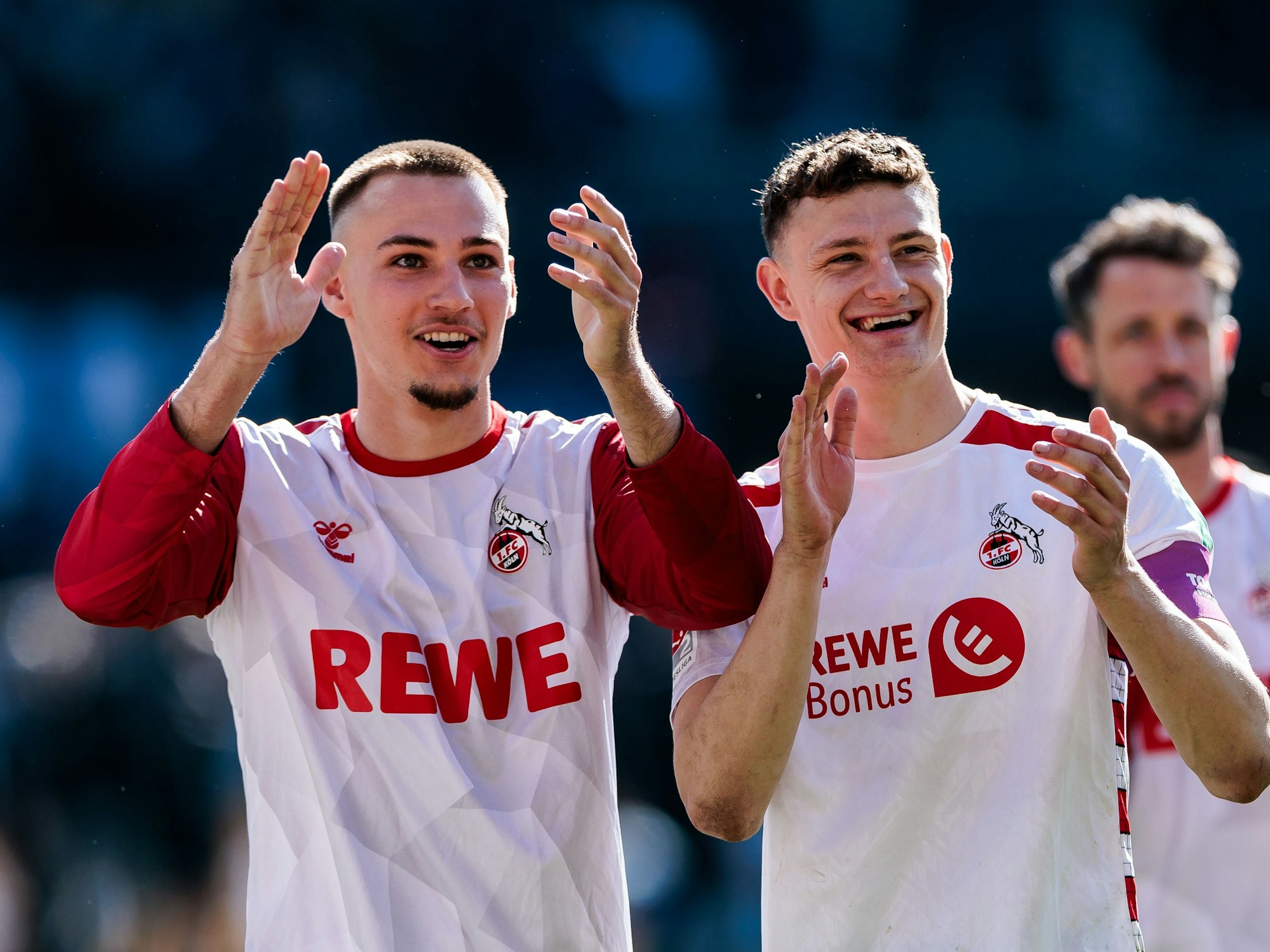 Tim Lemperle und Eric Martel lachen und applaudieren in Richtung der Fans.